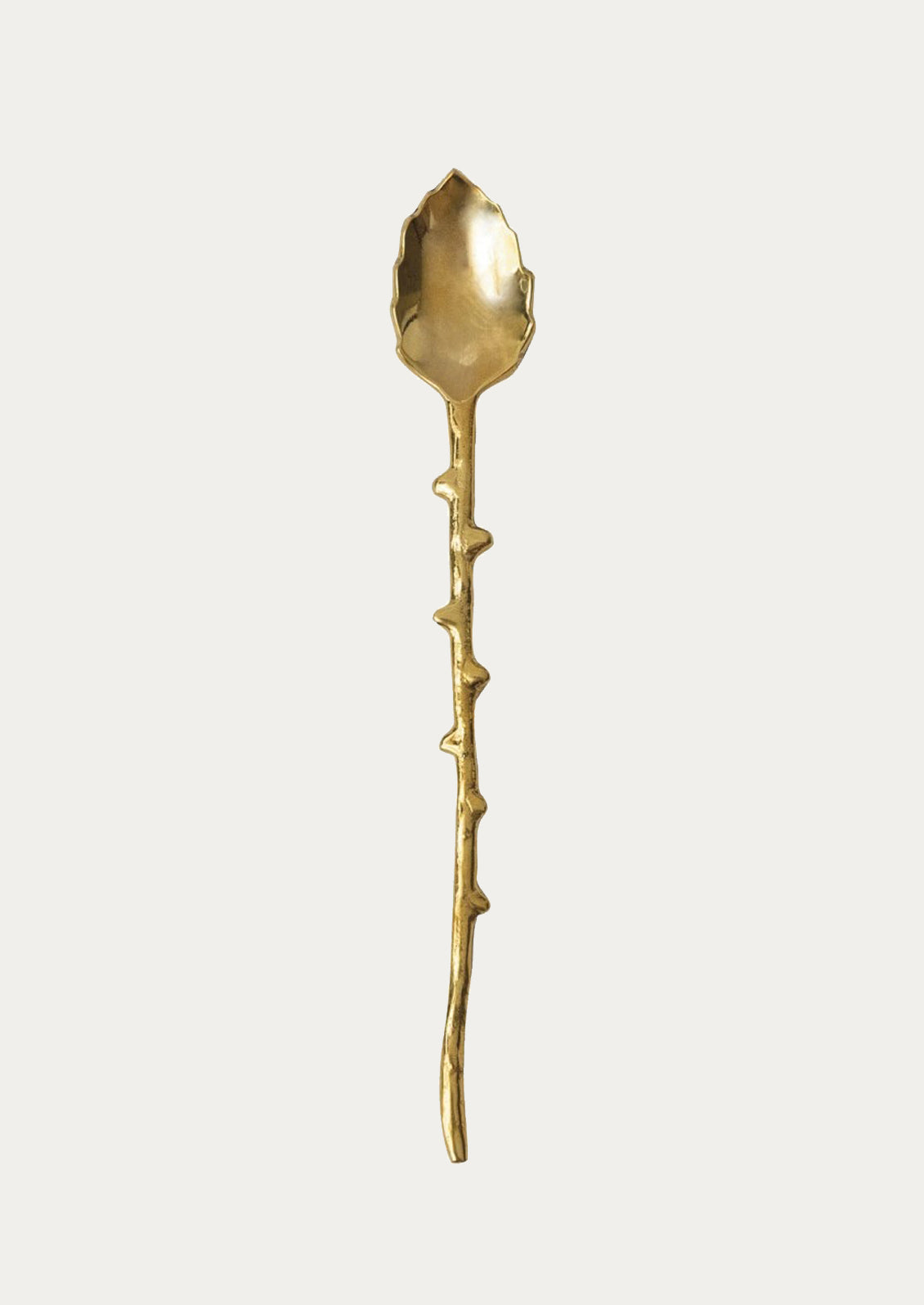 A brass spoon in leaf shape with twig-cast handle.
