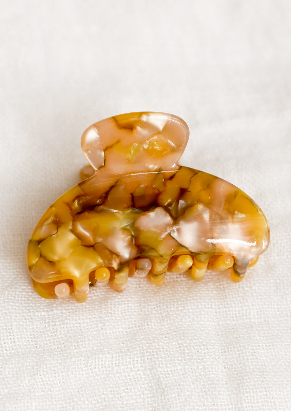 A small hair claw in sand and honey fleck pattern.