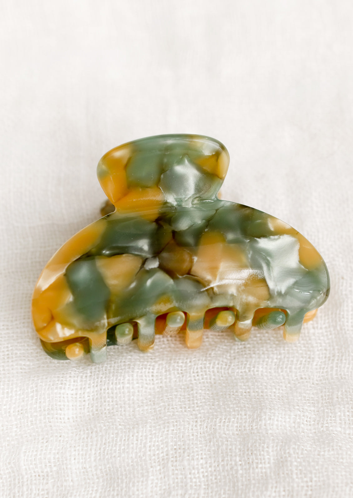 A small hair claw in sand and mint fleck pattern.
