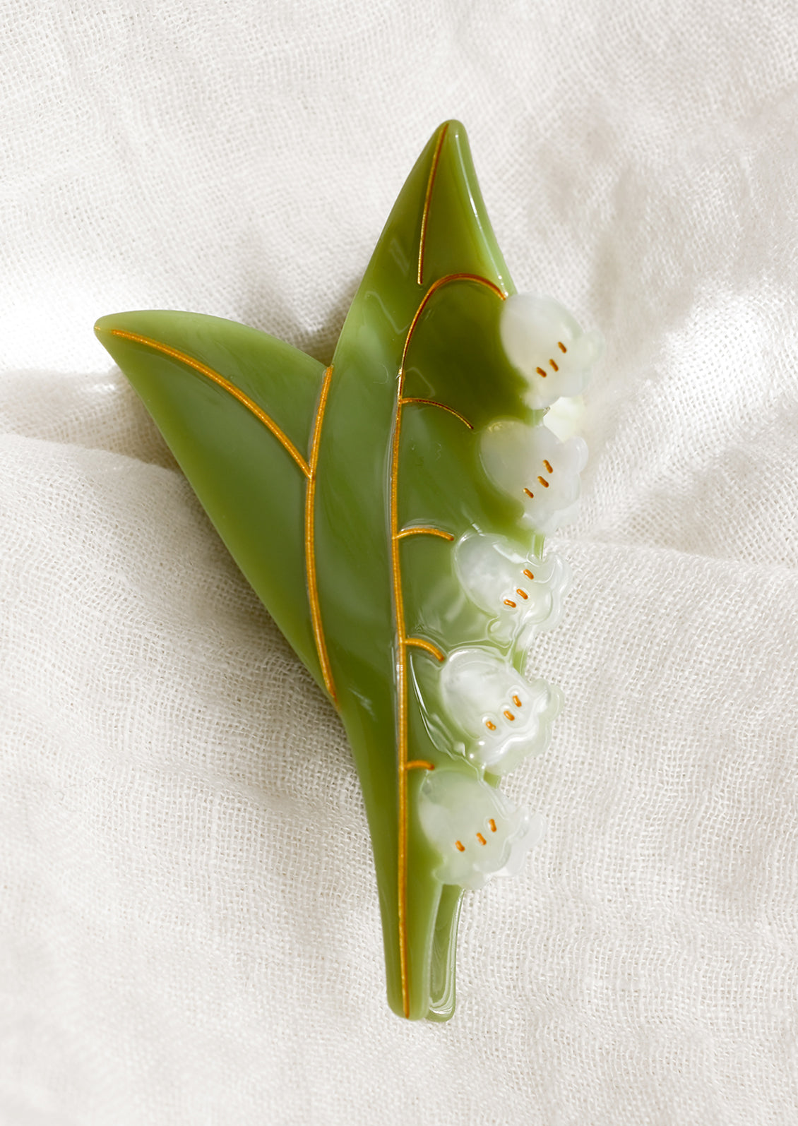 A hair claw in the shape of lily of the valley plant.