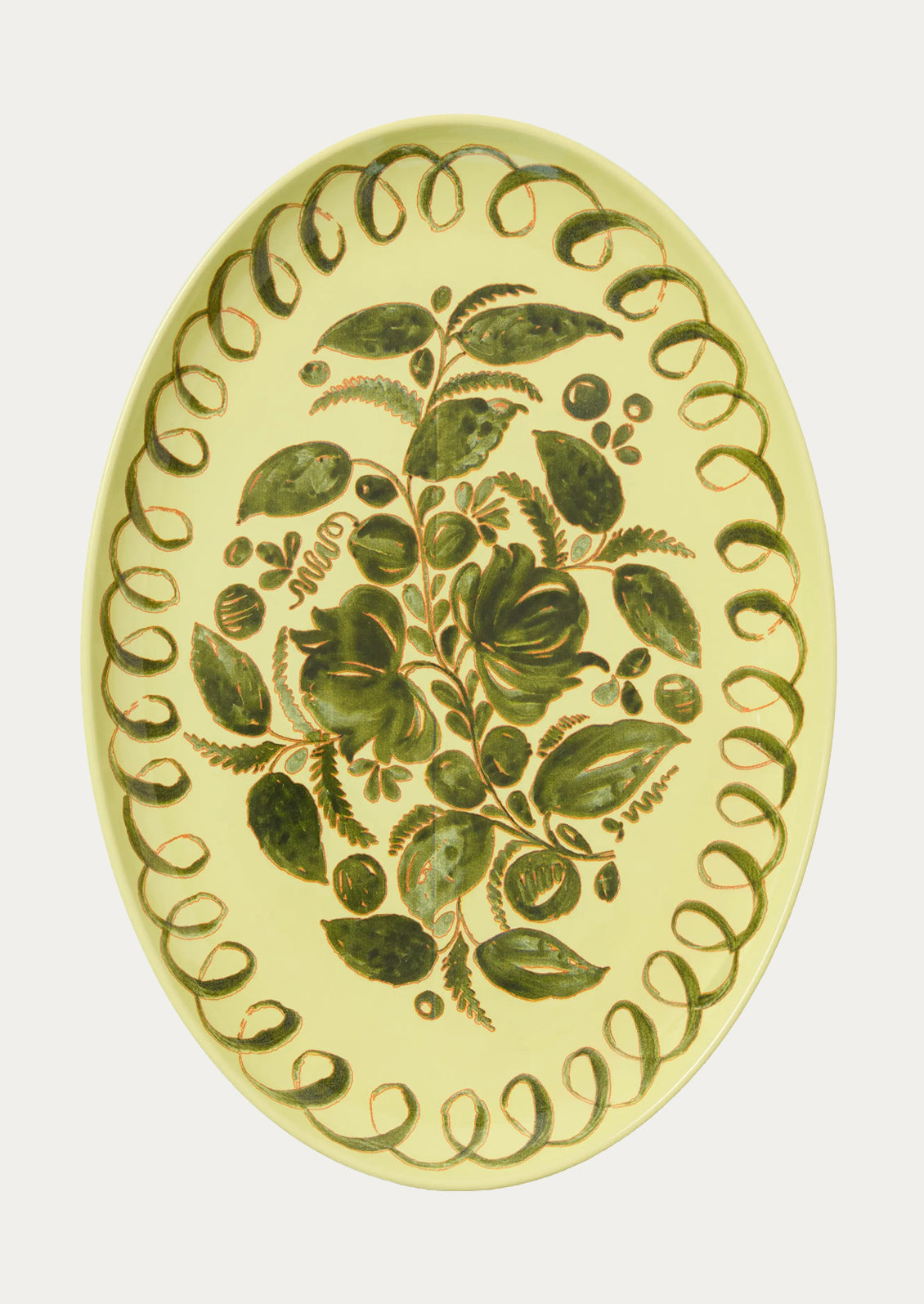 Decorative oval plate with green leaf pattern on a light yellow background