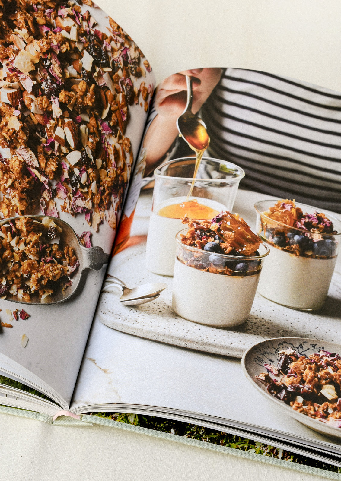 A cookbook open on a table showing an image of yogurt granola parfaits.