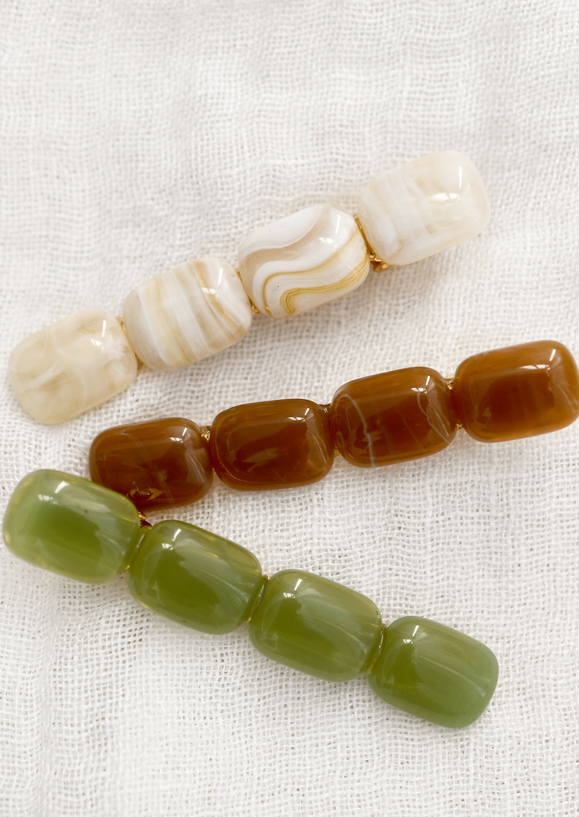 Lozenge hair barrettes in cream, brown and green.