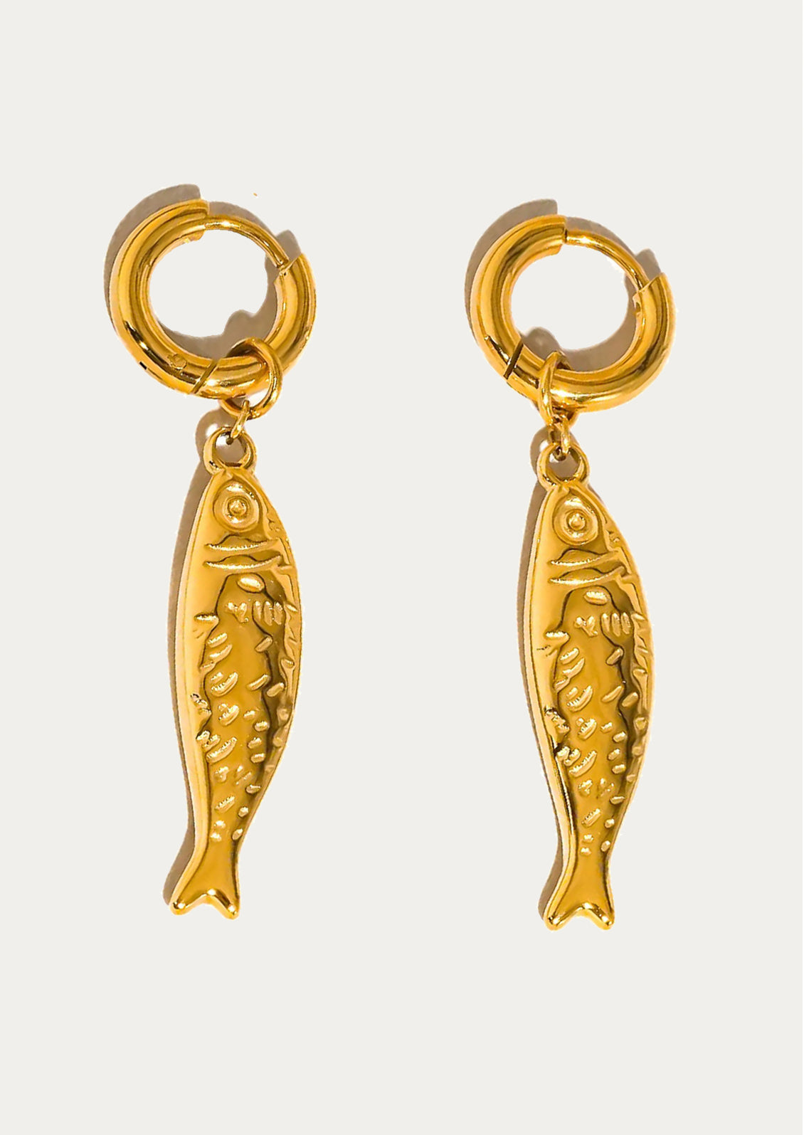 Gold fish-shaped earrings on a white background