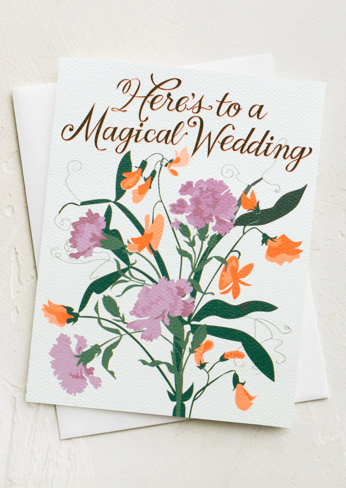 A floral print card reading "Here's to a magical wedding".