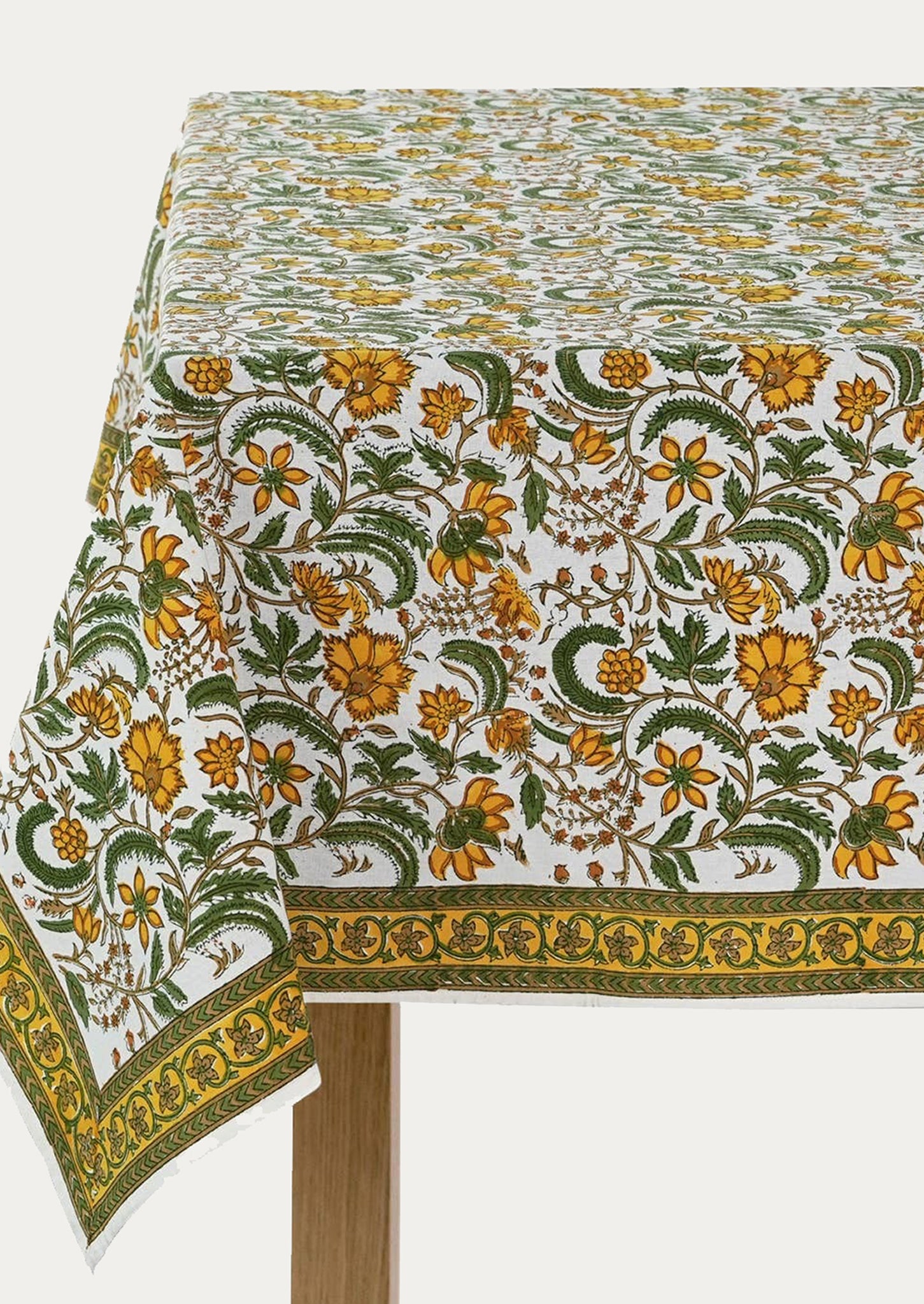 A block printed tablecloth in yellow and green floral pattern.