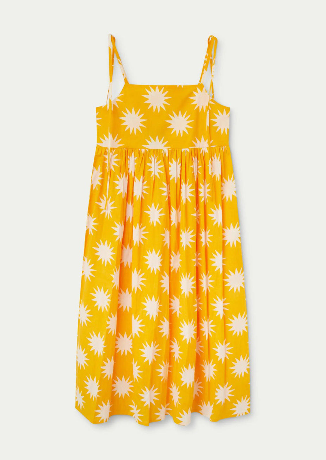 A yellow tie shoulder dress with big sun pattern in white.