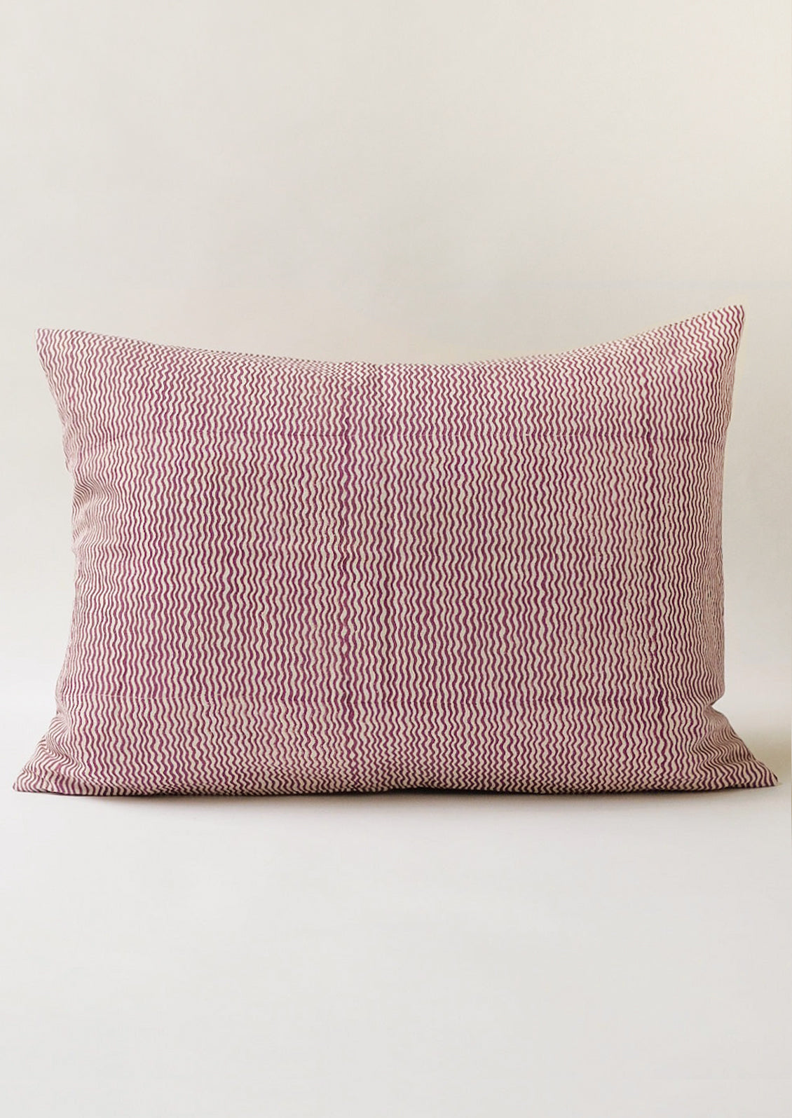 A lumbar throw pillow with wavy purple lines.