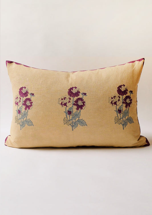 A lumbar throw pillow in sand color with purple flowers.