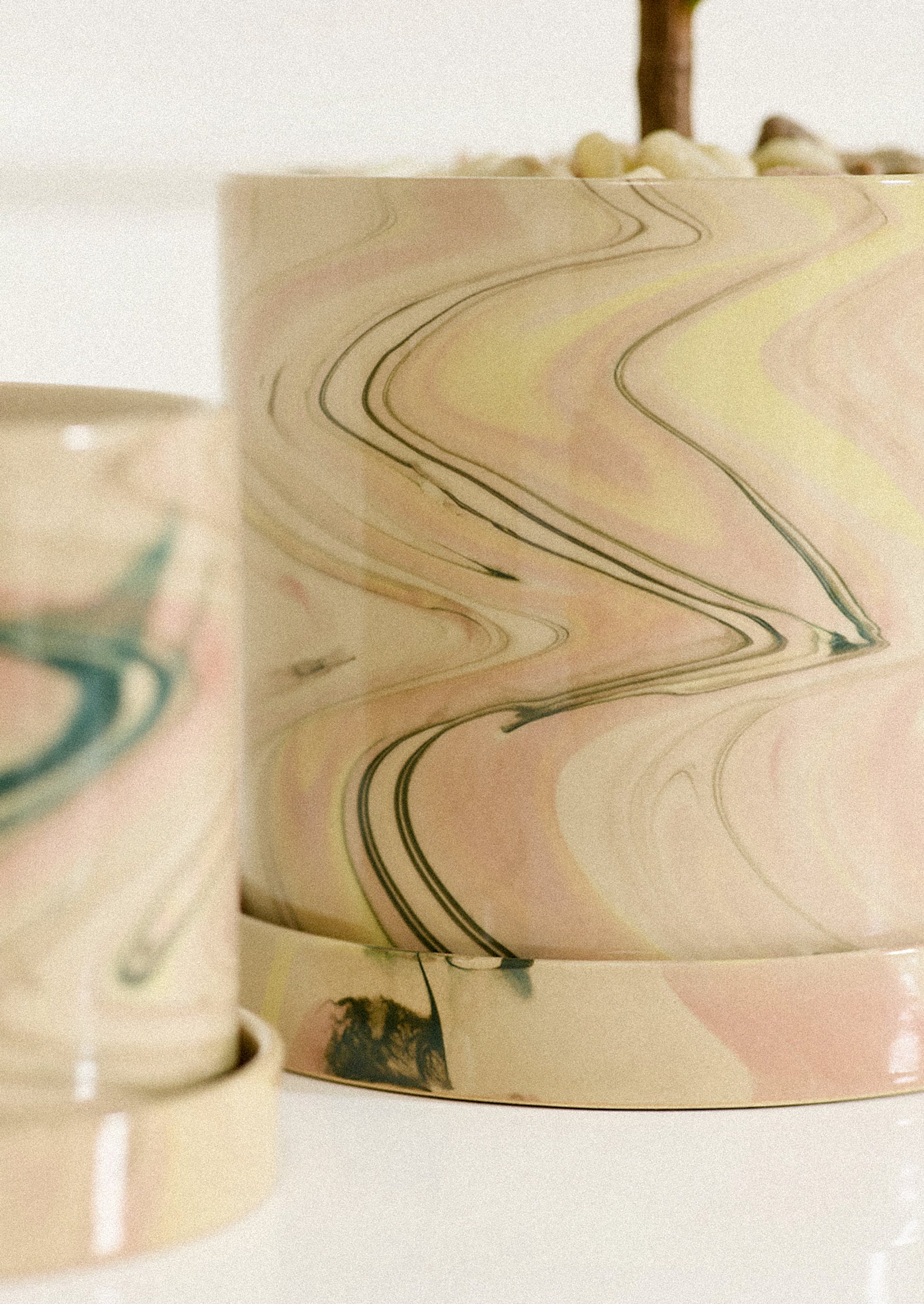Marbled ceramic containers with wavy pattern on a white background