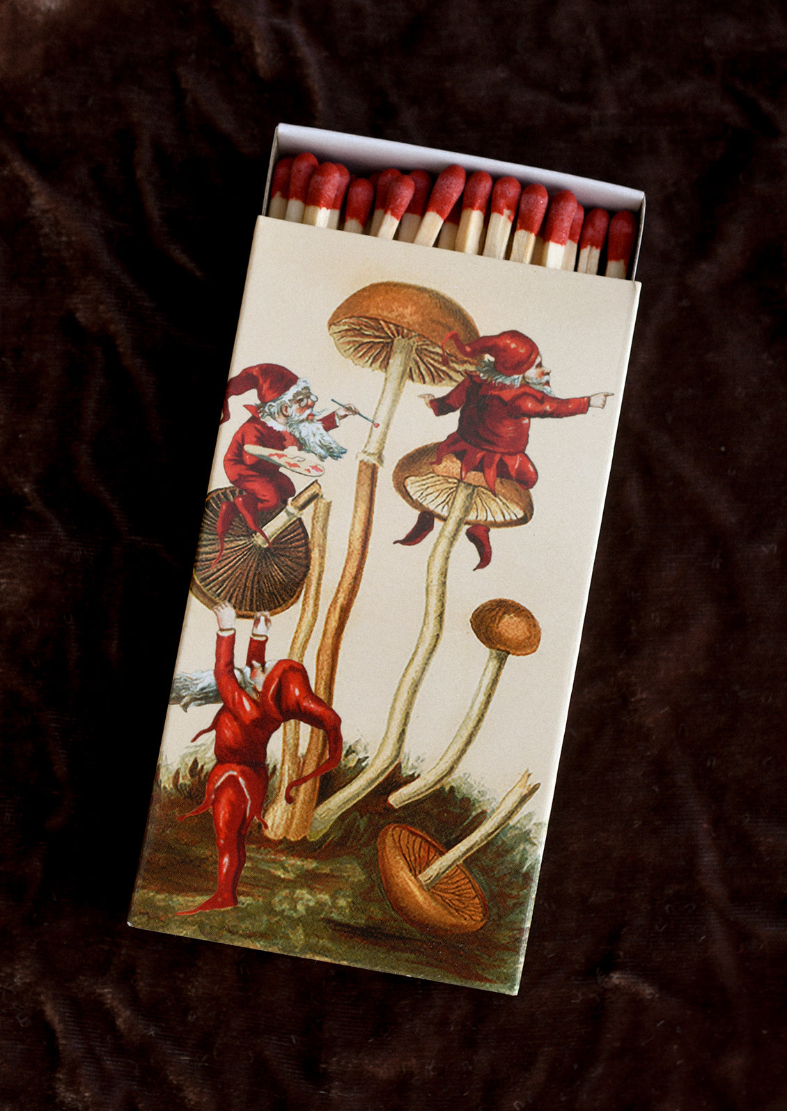 An elf and mushroom printed matchbox with red tipped matches.