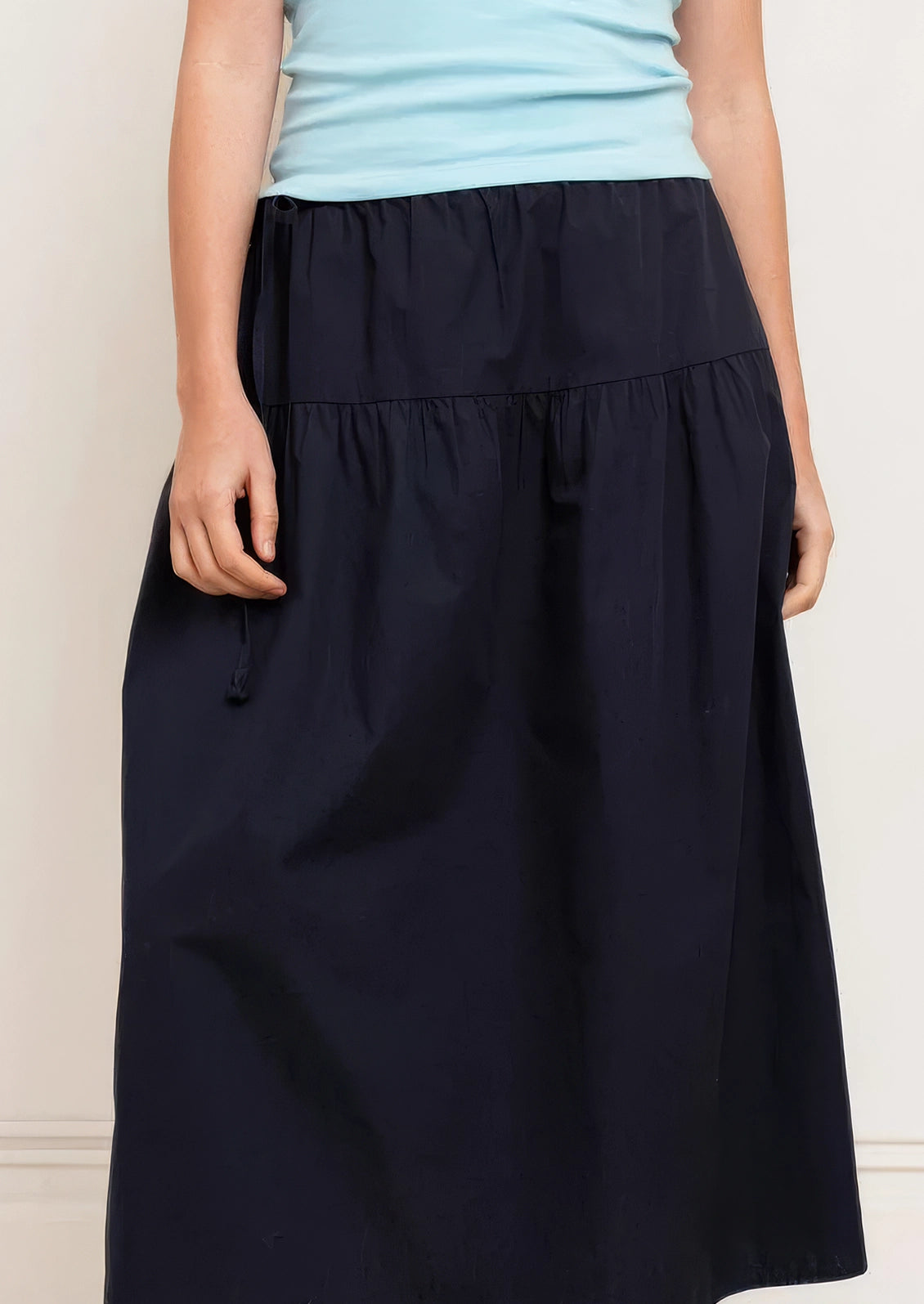 A person wearing a navy midi skirt.