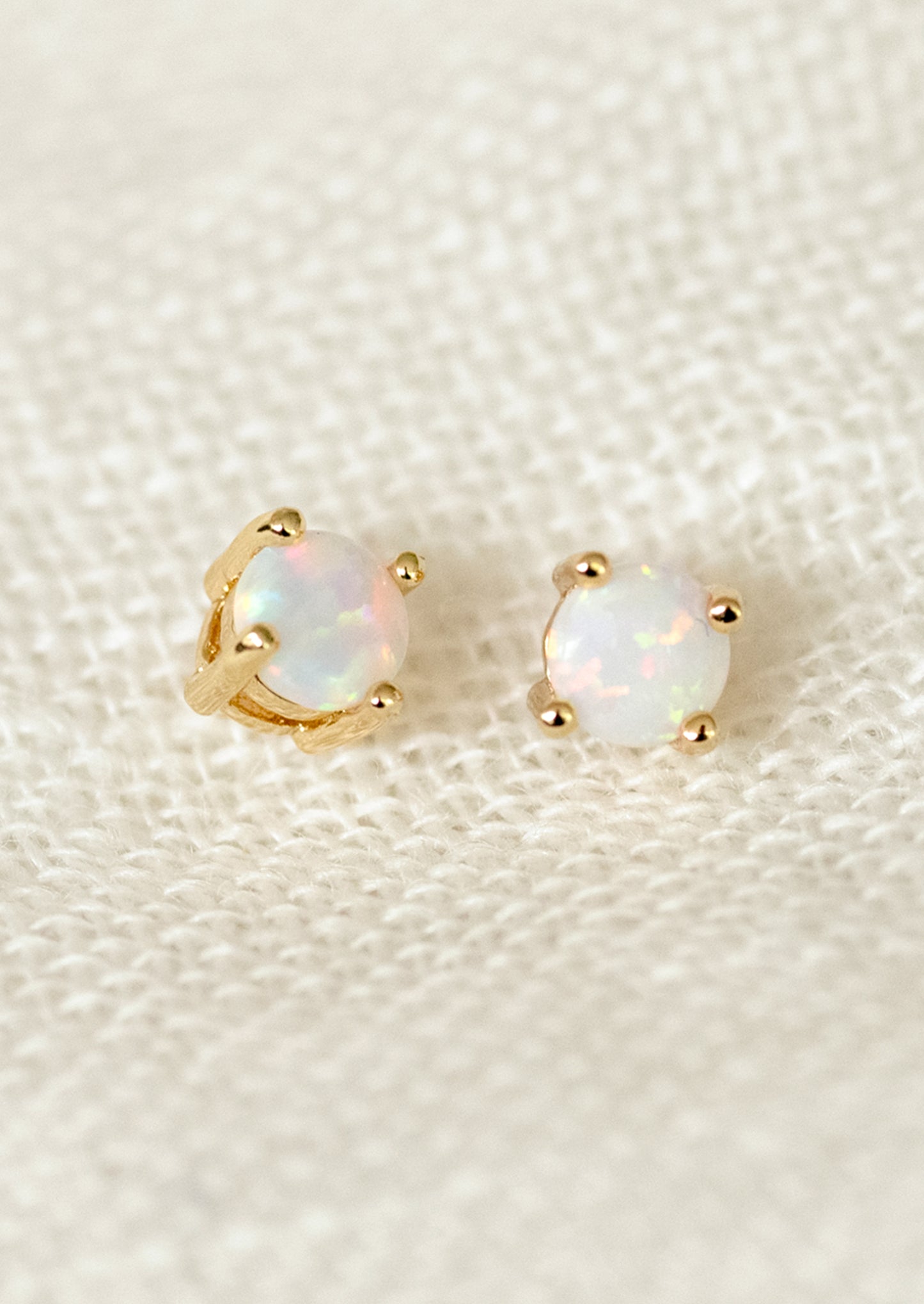 A pair of minimal stud earrings with opal stones.