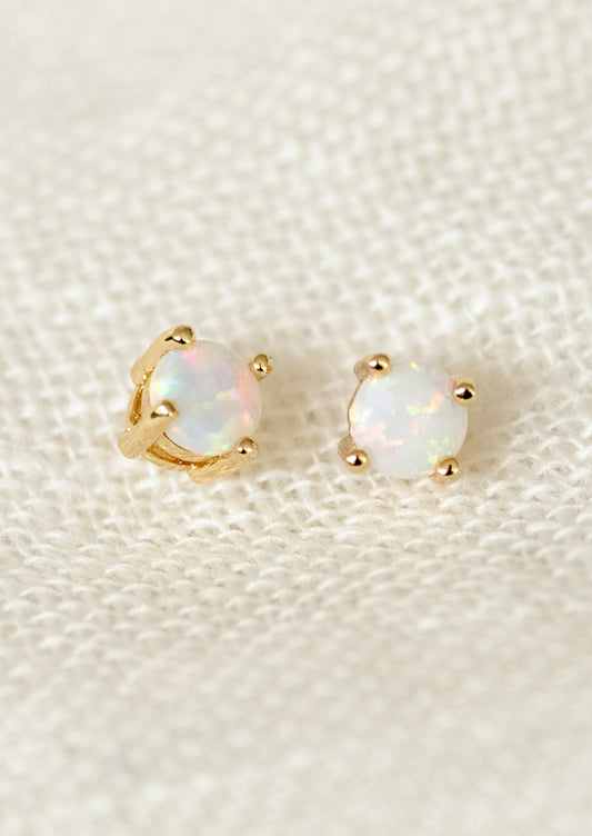 A pair of minimal stud earrings with opal stones.