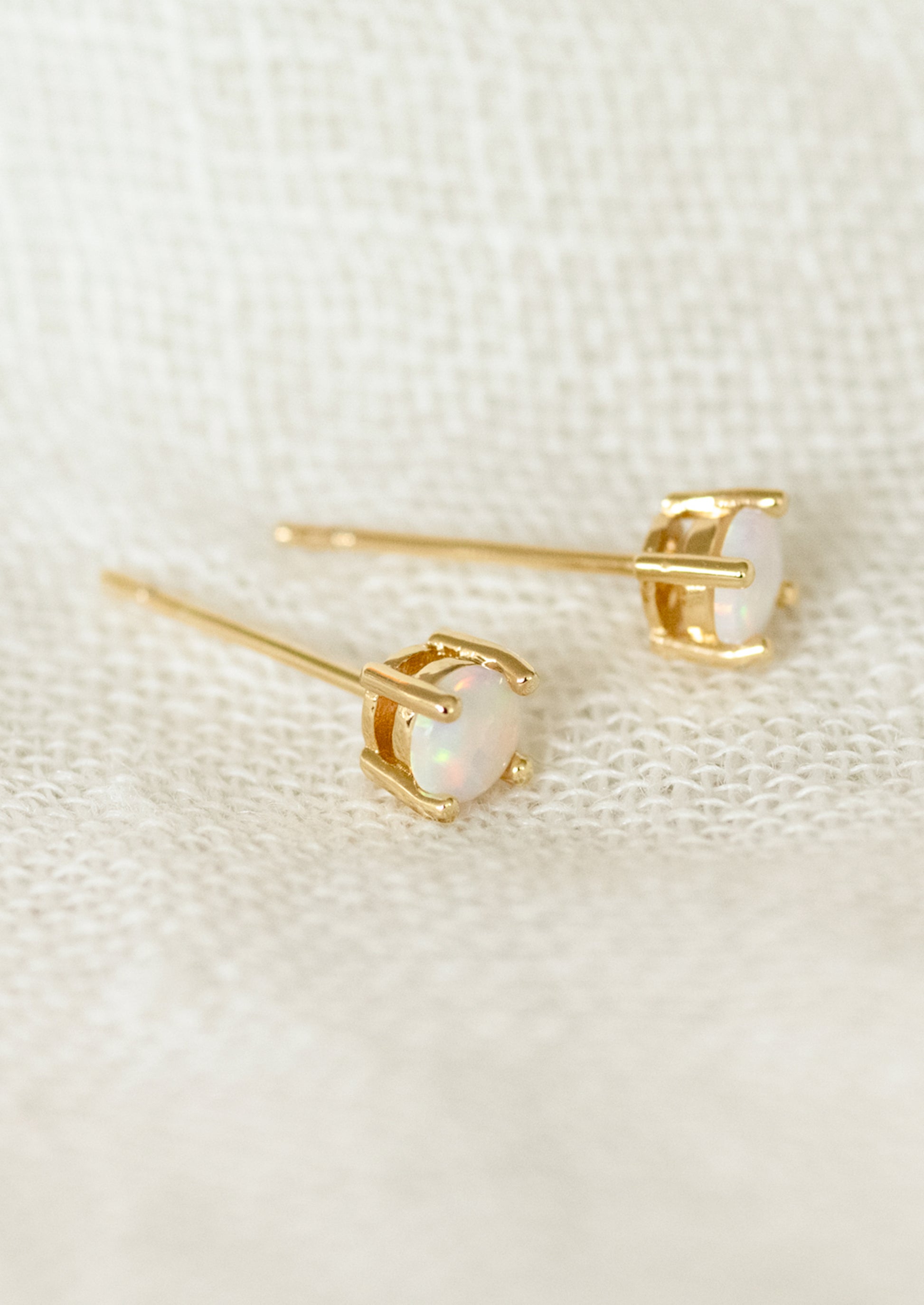 A pair of minimal stud earrings with opal stones.