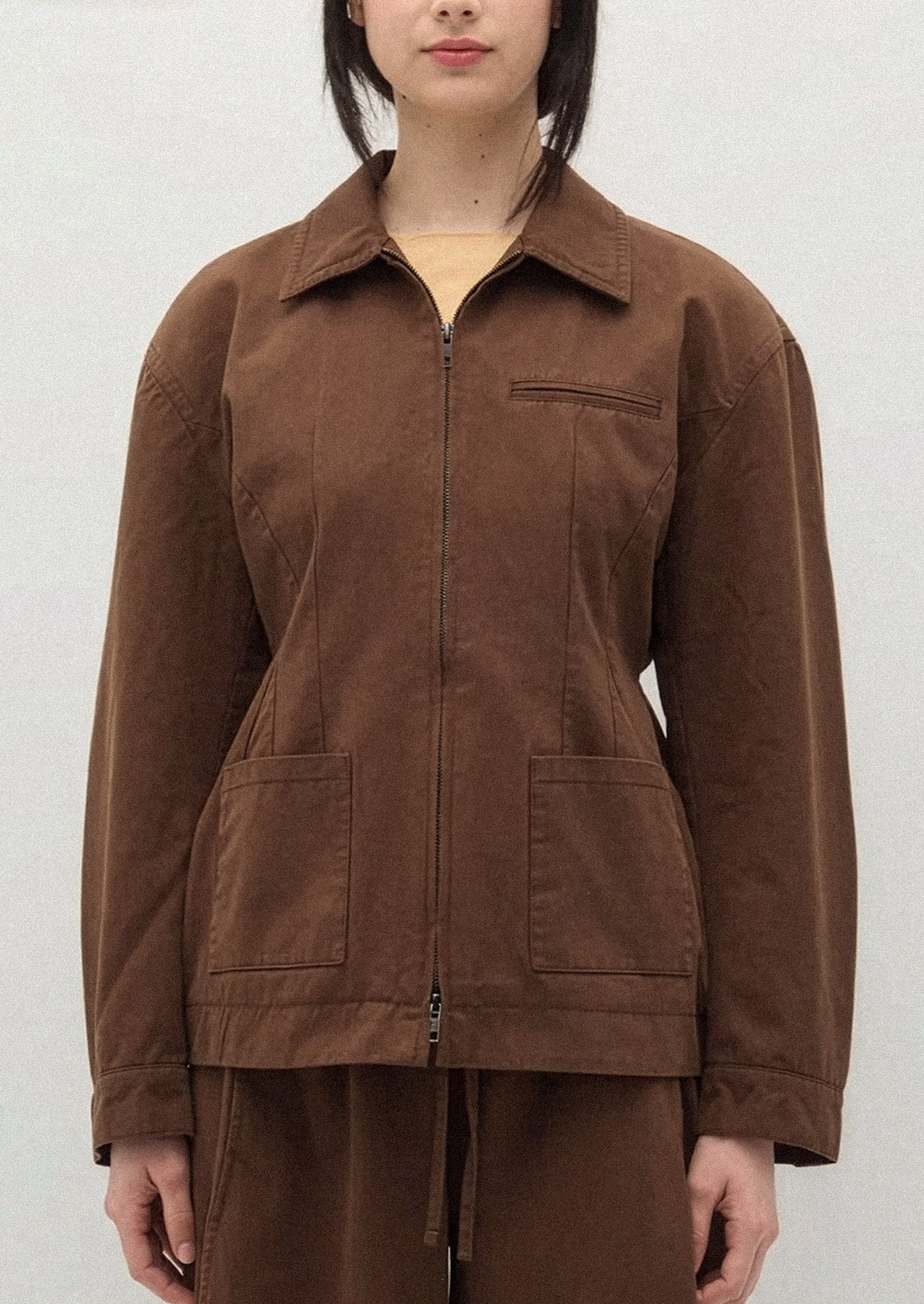 A person wearing a brown jacket