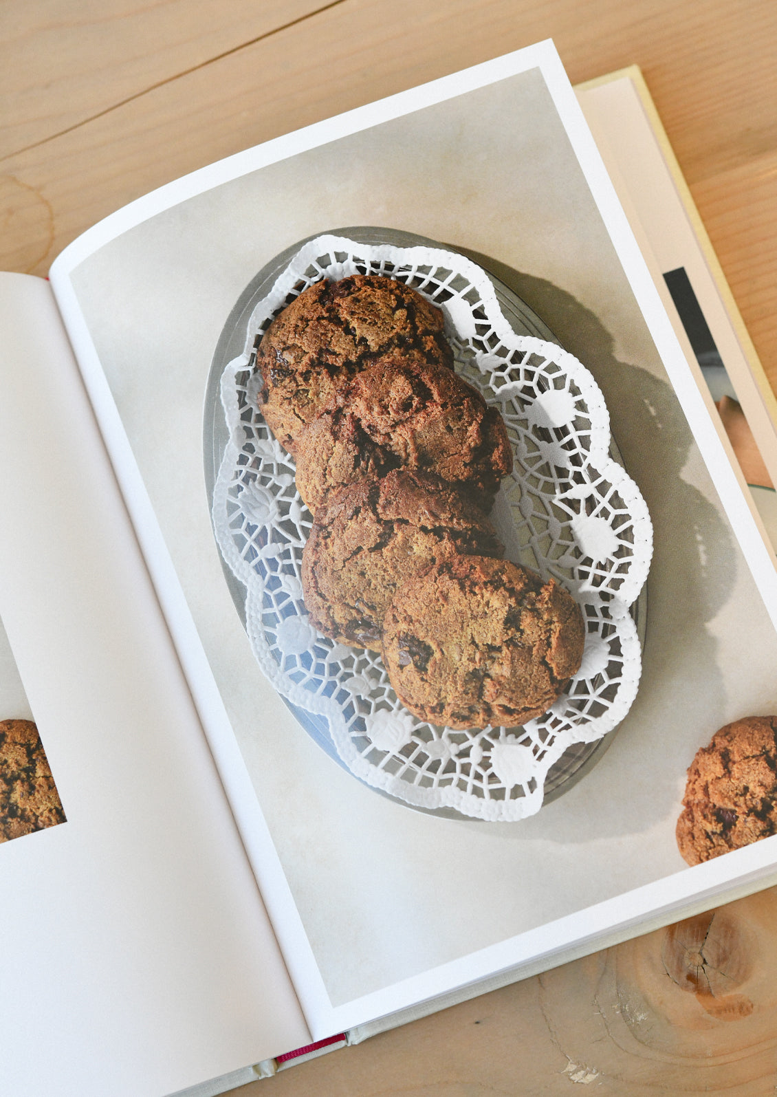 An open cookbook showing cookies in a serving platter.