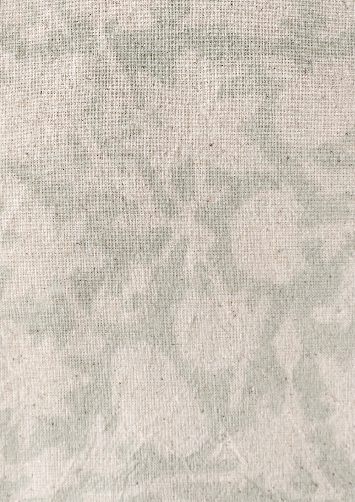 A block printed tablecloth in white floral print on very light seafoam background.