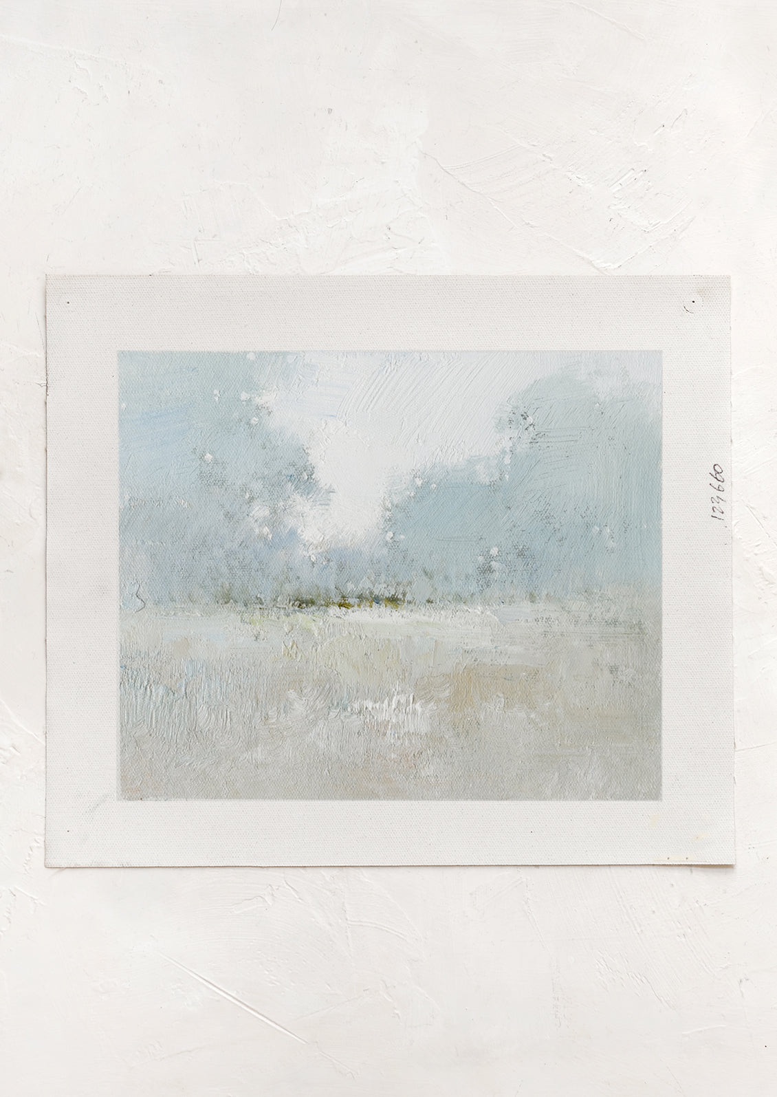An original oil painting on unstretched canvas of pale colored landscape.
