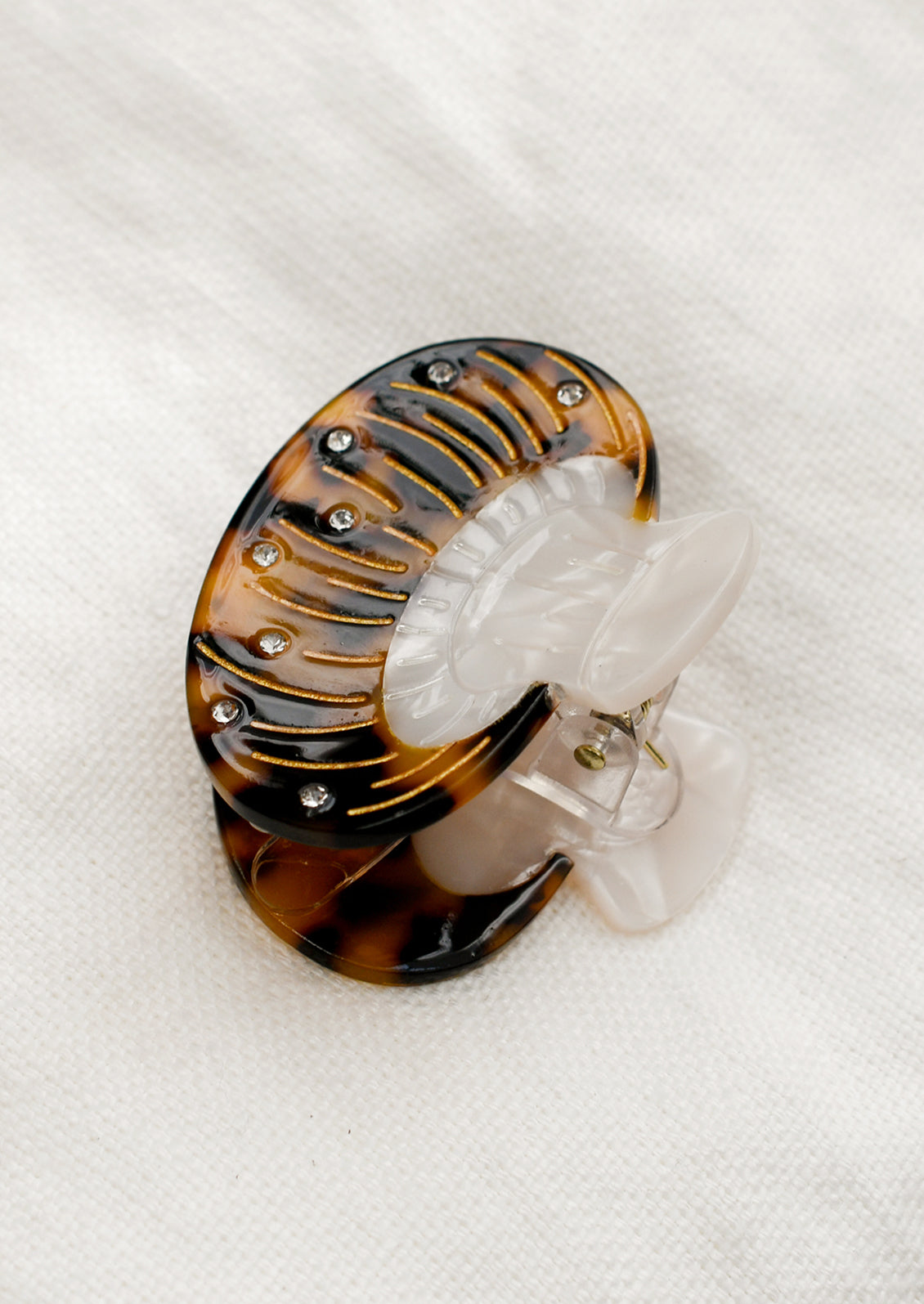 A hair claw in the shape of a brown mushroom with crystal detailing.