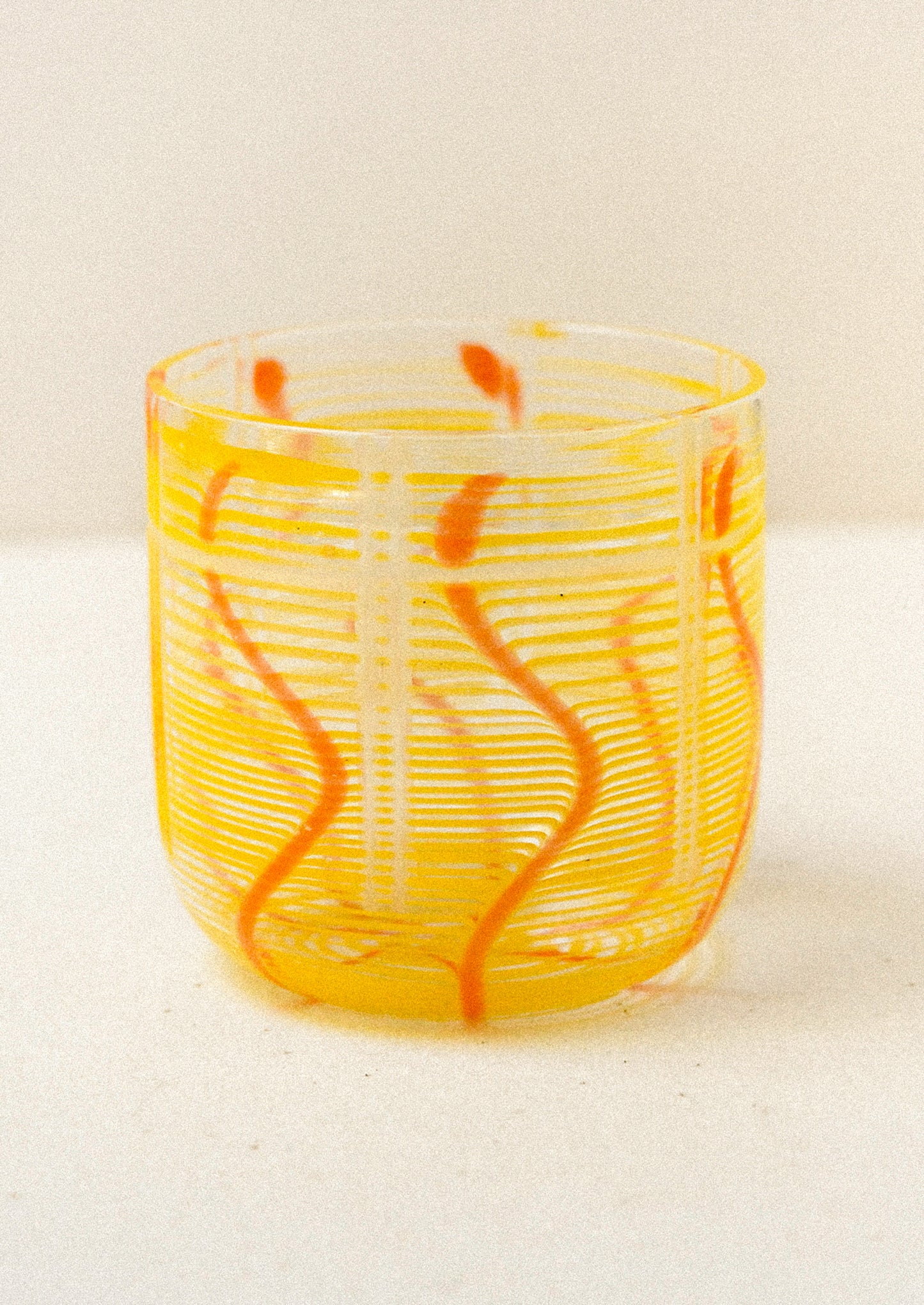 Yellow glass with orange swirls on a white background