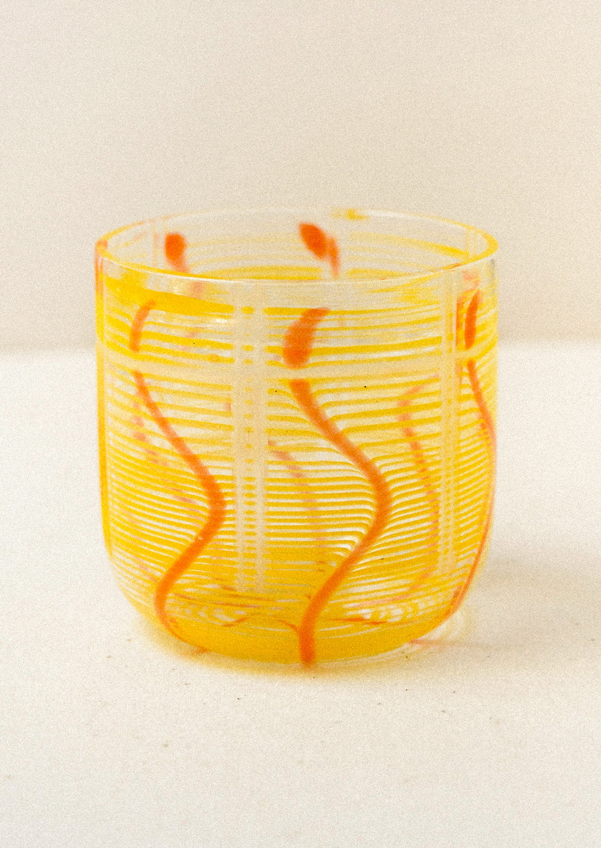 Yellow glass with orange swirls on a white background