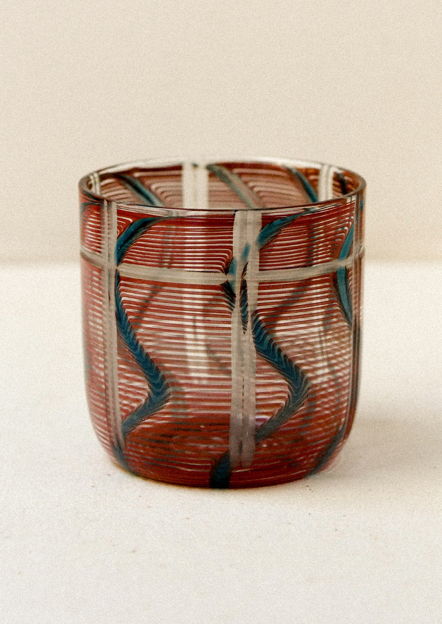 Decorative glass with red and green pattern on a beige background