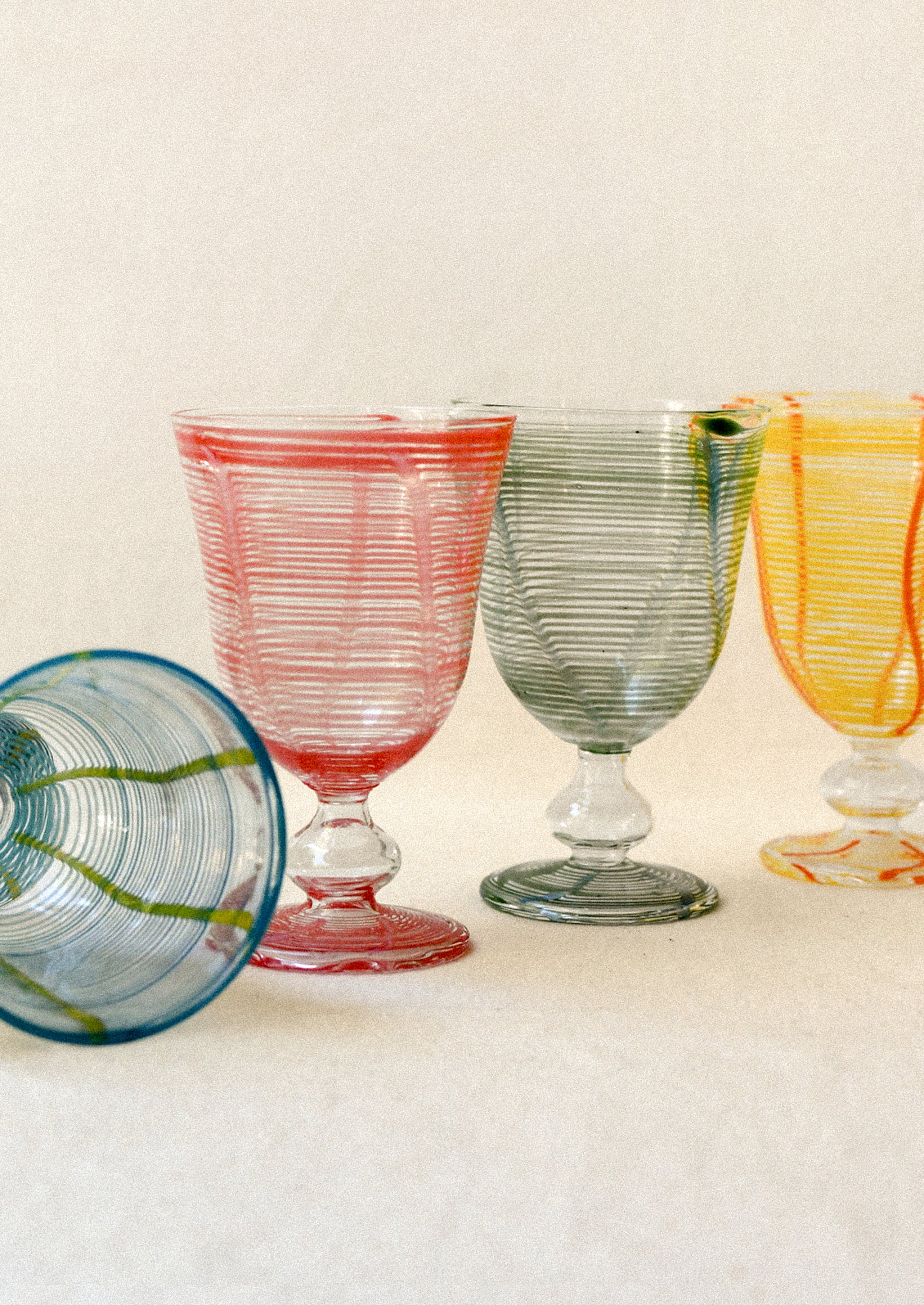 Set of colorful glass goblets on a light background