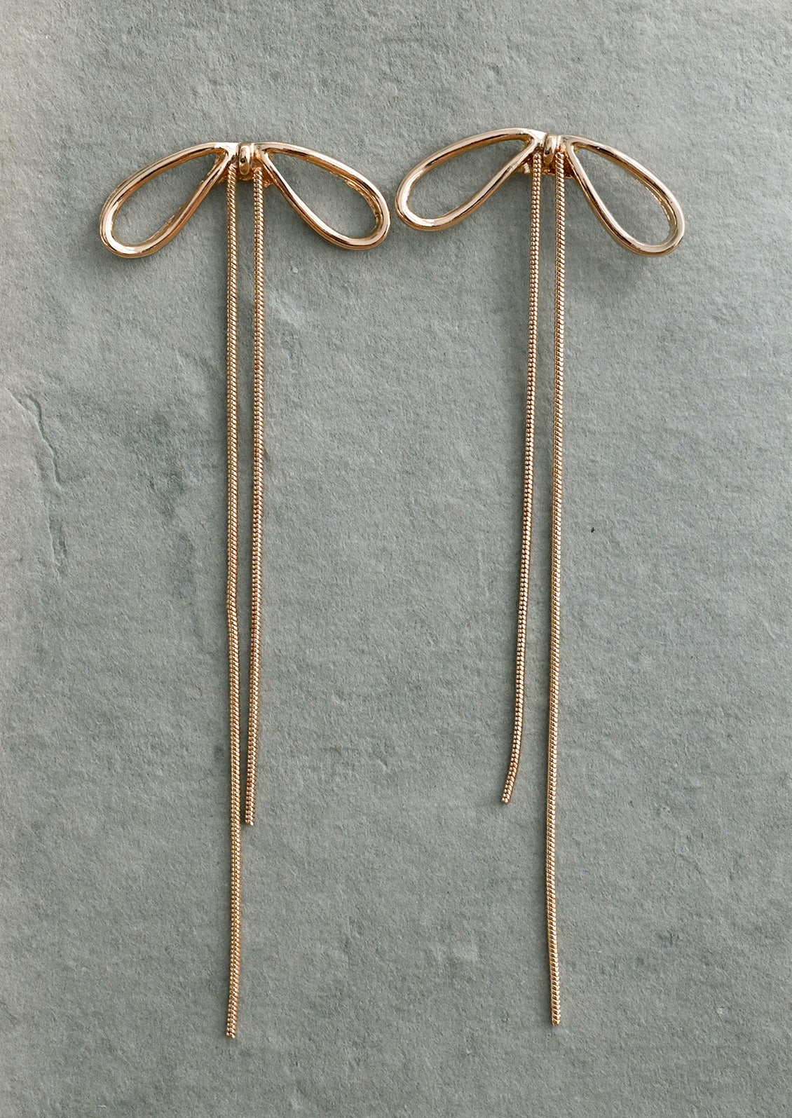 A pair of bow earrings with long chain drop.