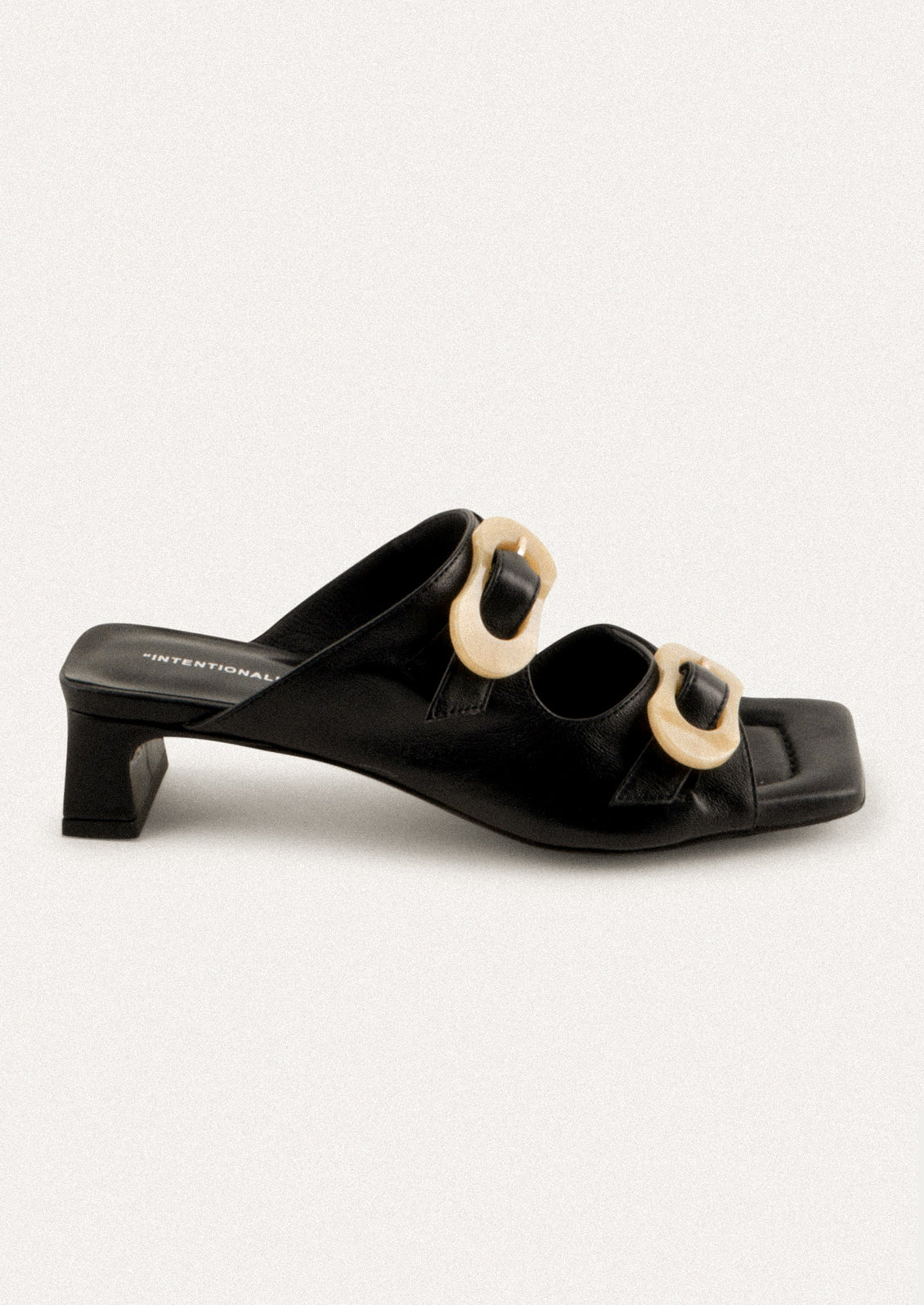 A square toe heeled sandal in black with double tan buckle detail.