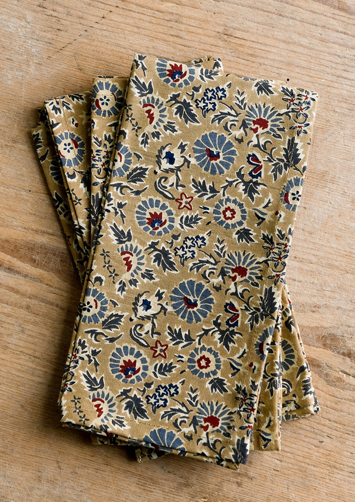 A floral print napkin set in brown, indigo and red.