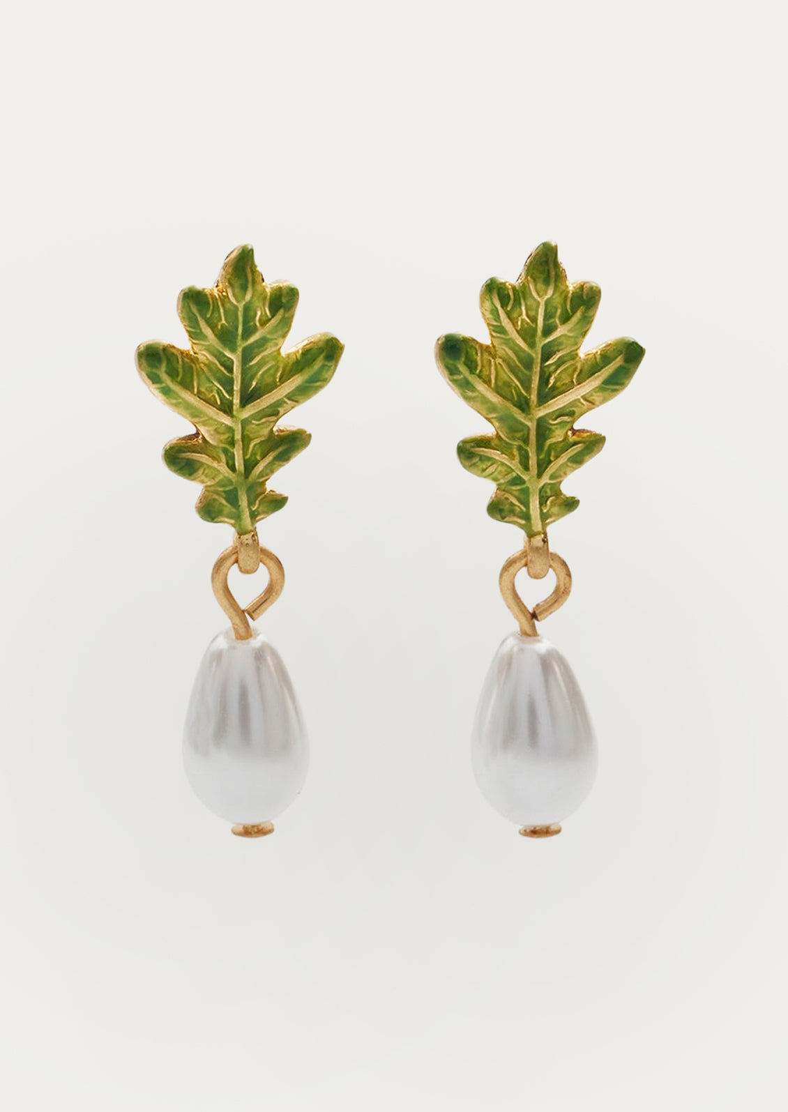 A pair of oak leaf earrings with large pearls dangling at the ends.