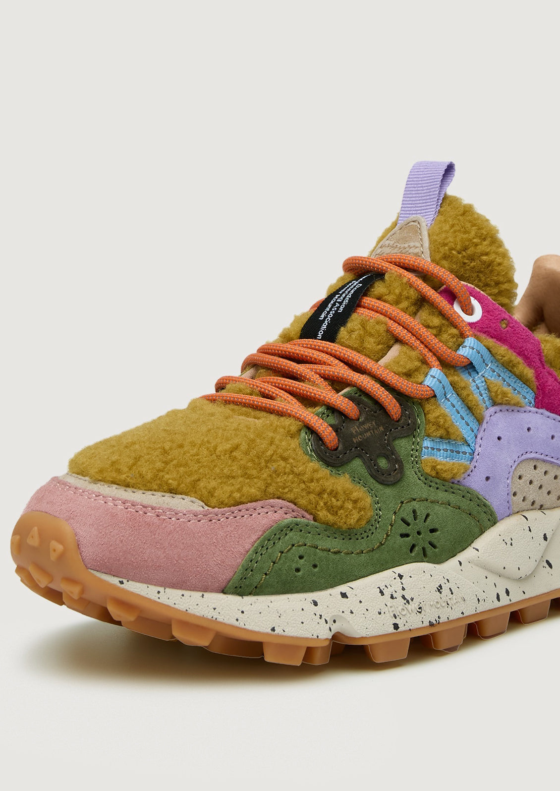 A pair of sporty sneakers in bright multicolor with ochre shearling upper.
