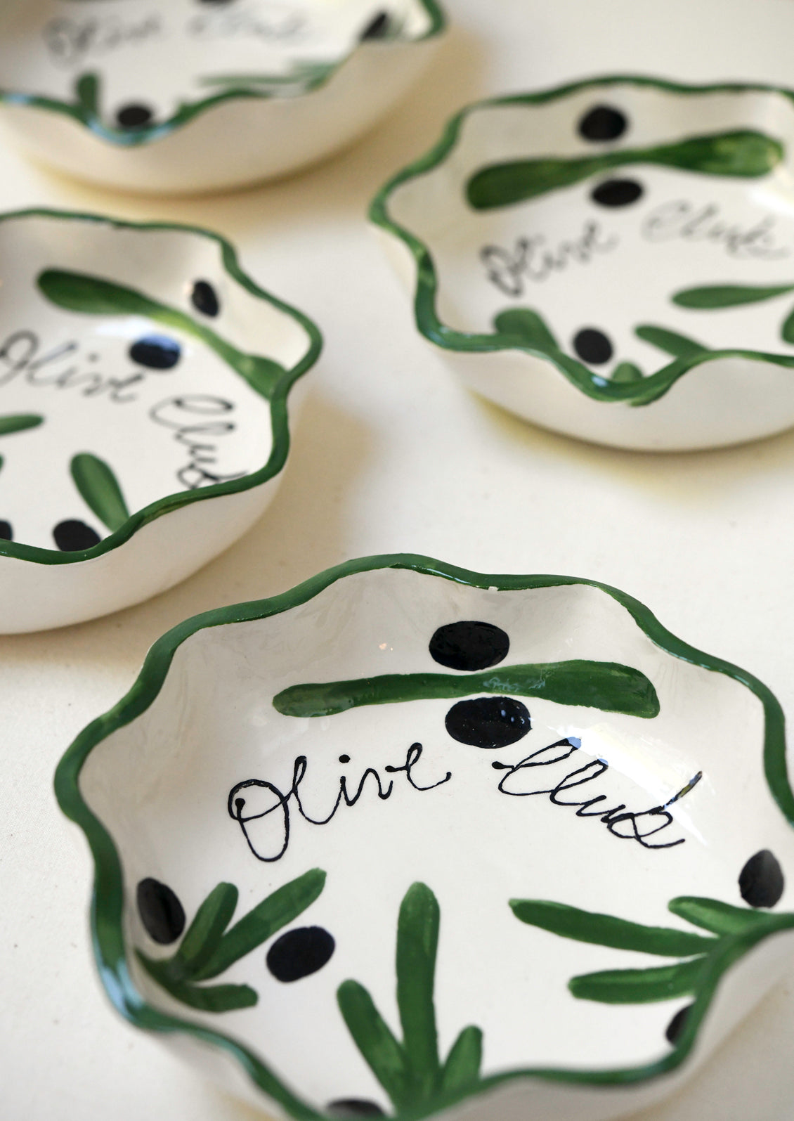 Handmade ceramic dishes with an illustrated olive design.