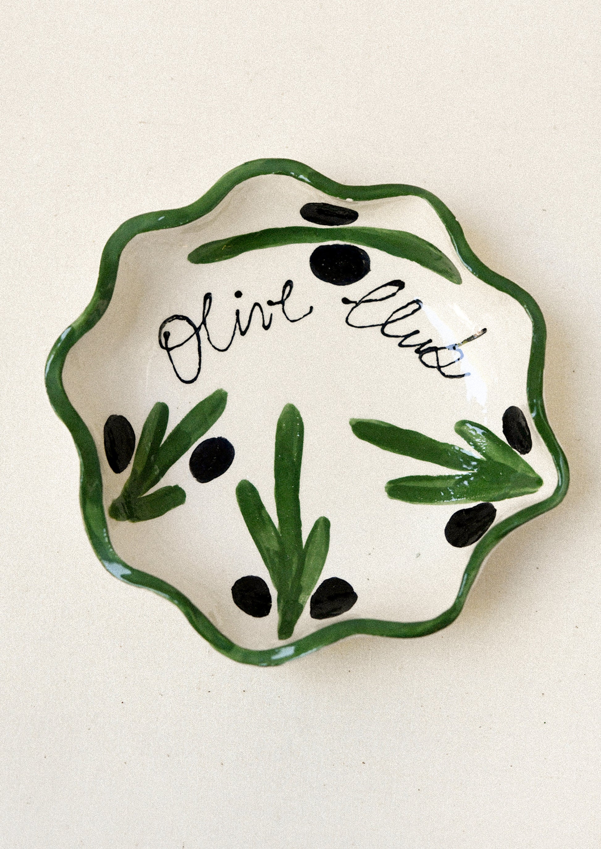 A ceramic dish with an illustrated olive design.