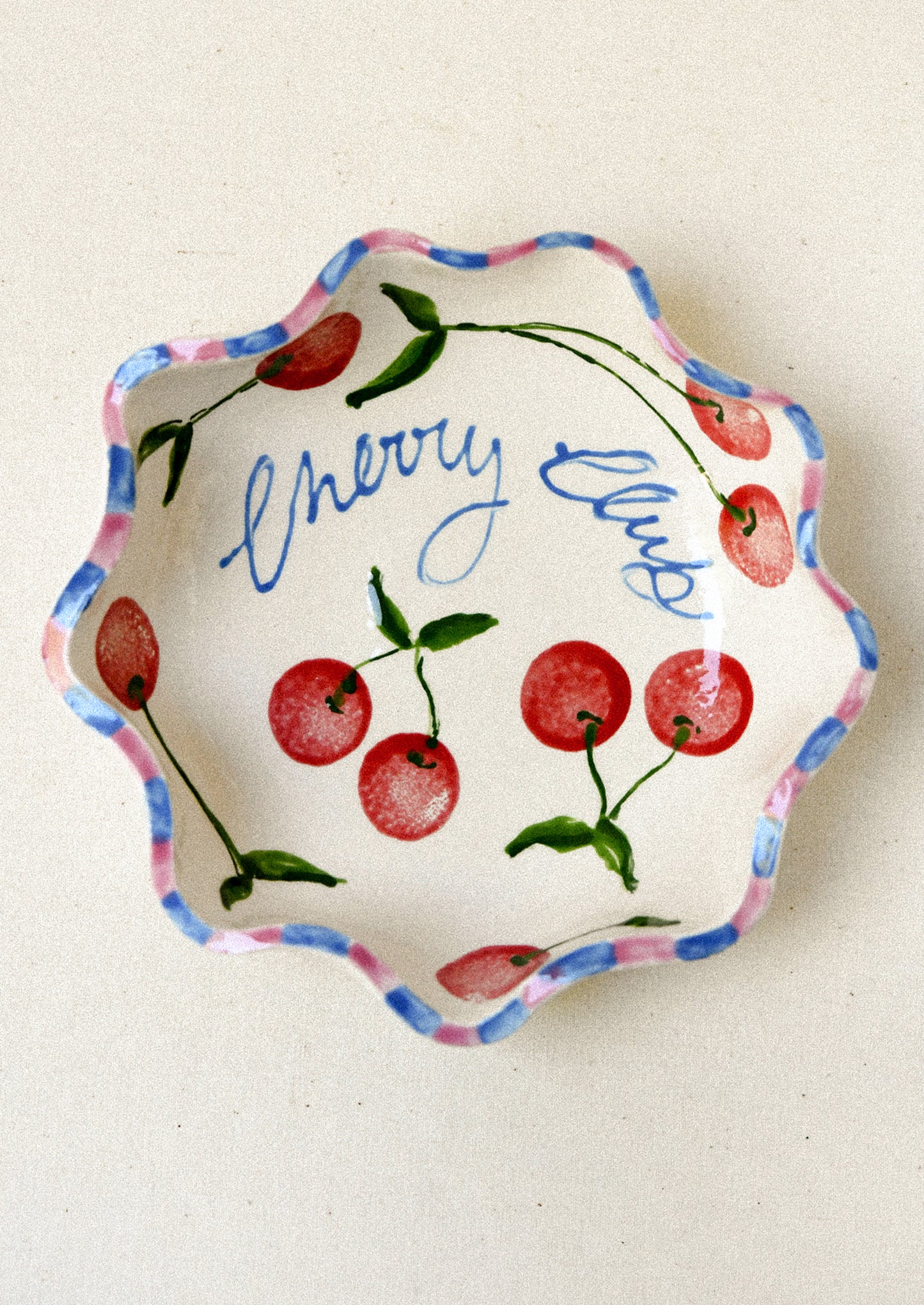 A ceramic dish with an illustrated cherry design.