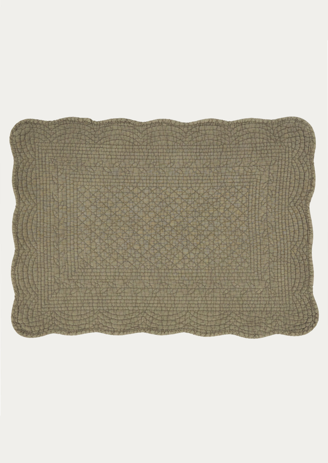 A quilted cotton placemat with scalloped edges, in olive color.