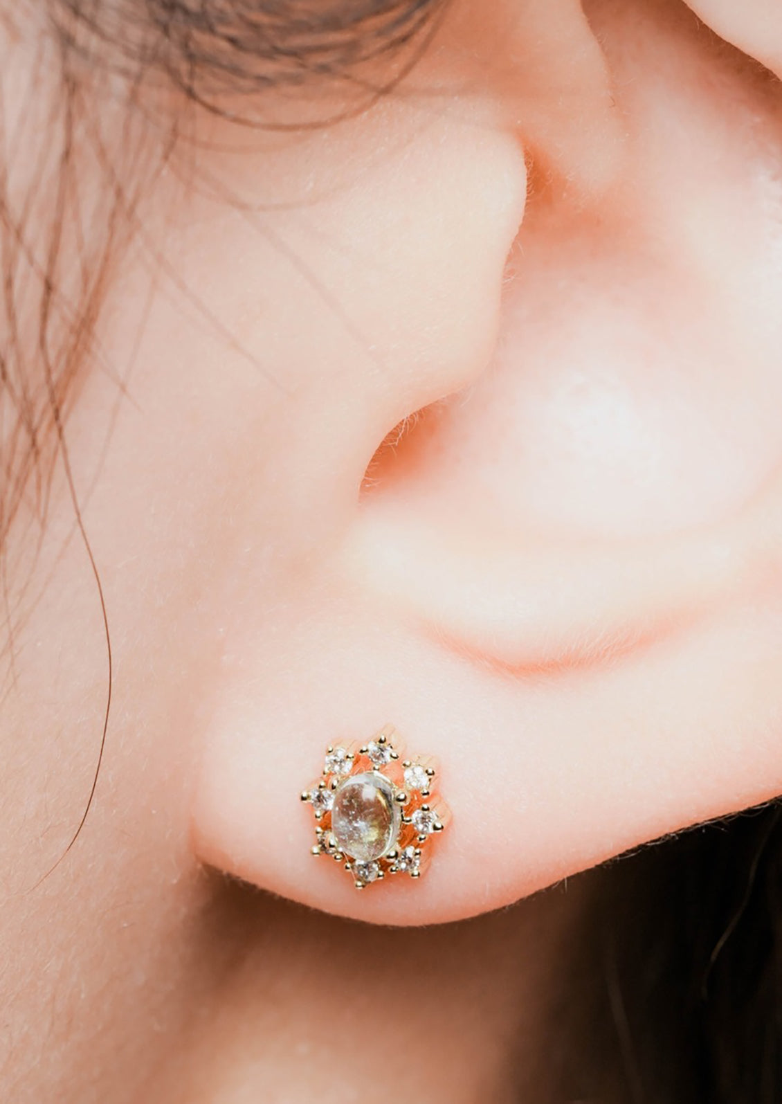 A pair of aquamarine and clear crystal gold stud earrings in sun shape.