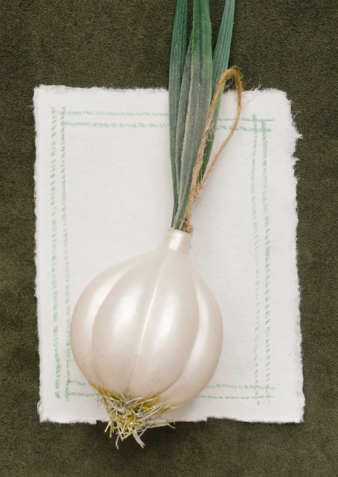 A glass ornament resembling a large white onion with stalk.