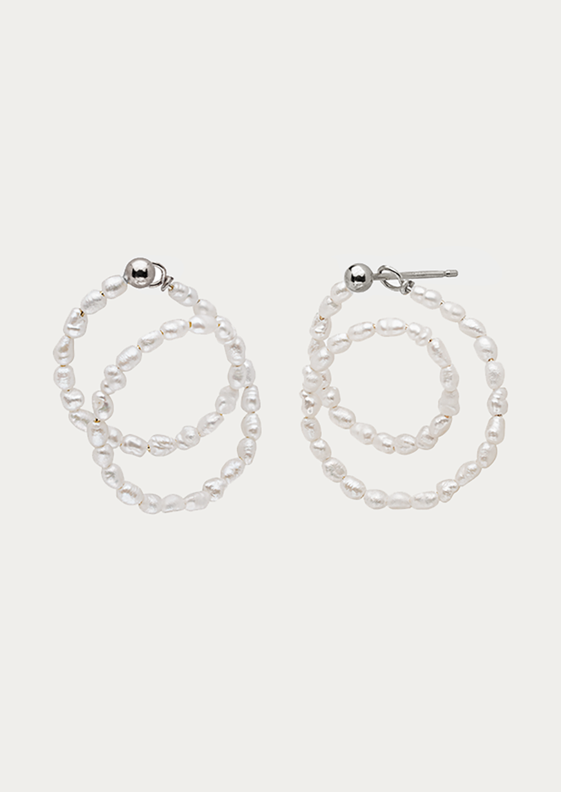 A pair of looped beaded pearl earrings with sterling silver ball post.