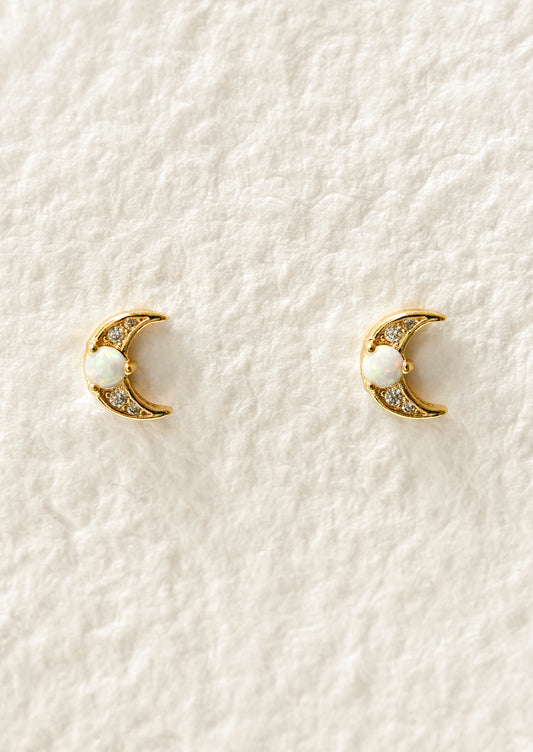 A pair of gold moon-shaped earrings with opal gemstones.