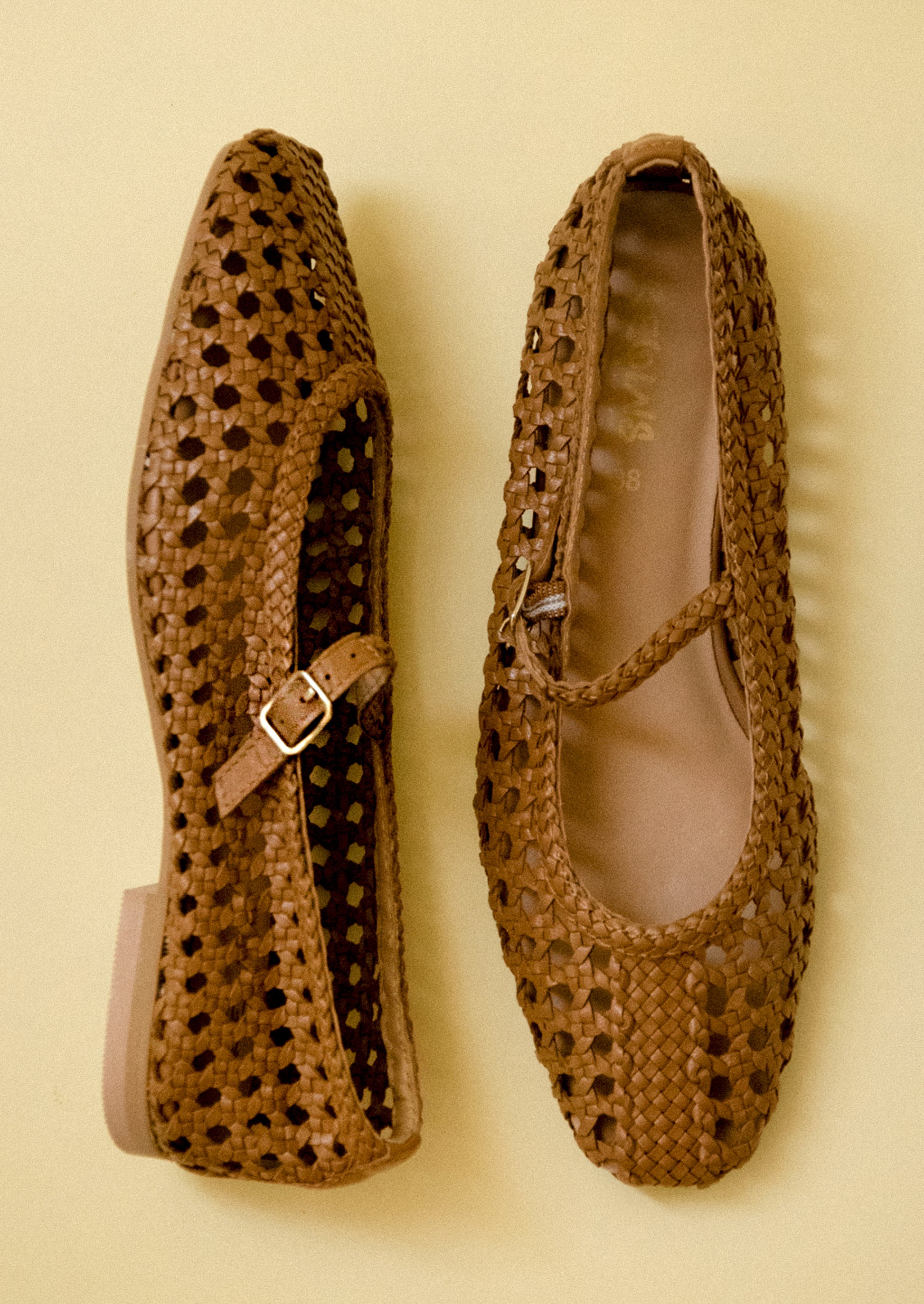 A pair of brown open weave ballet flats.