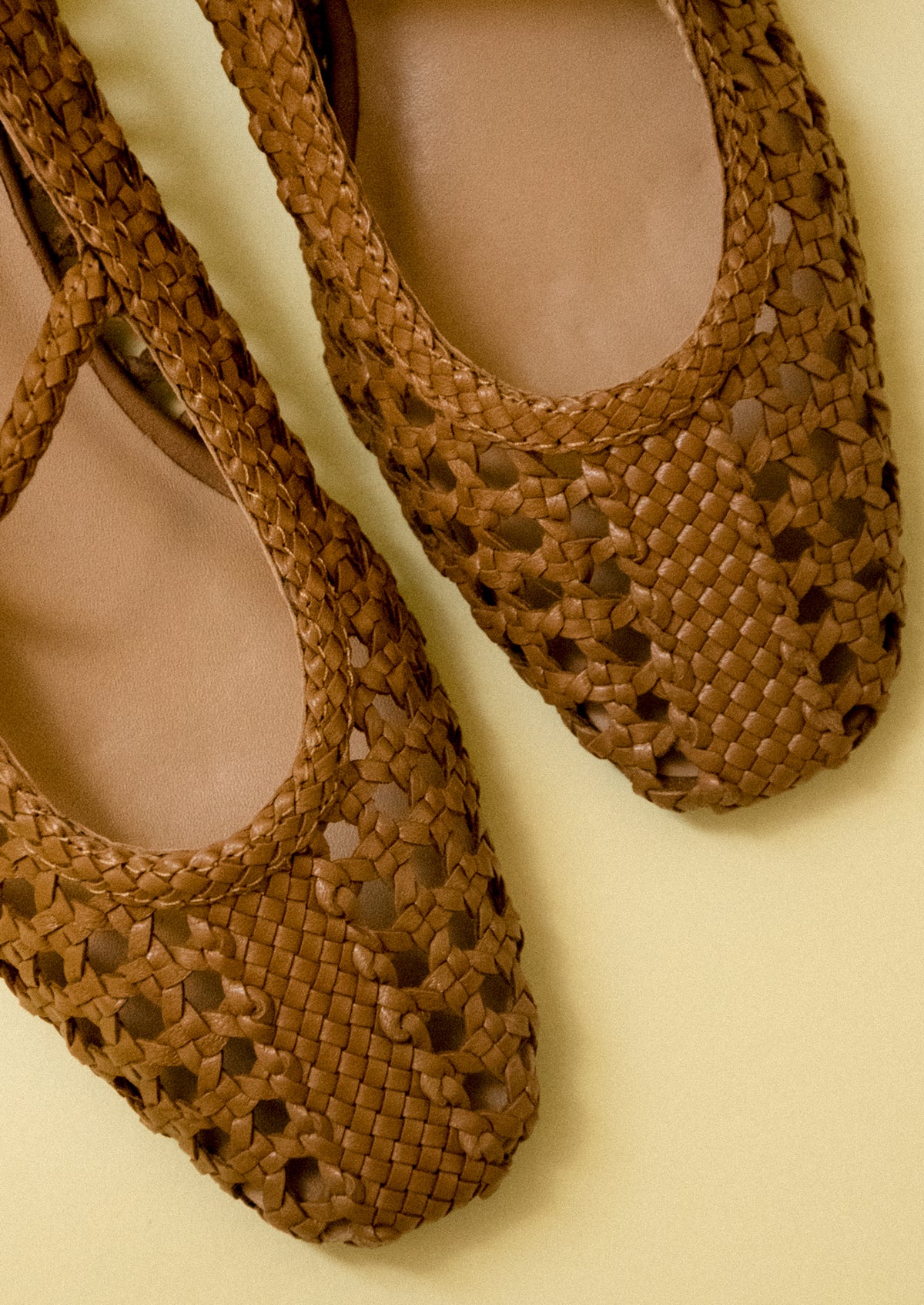 A pair of brown open weave ballet flats.