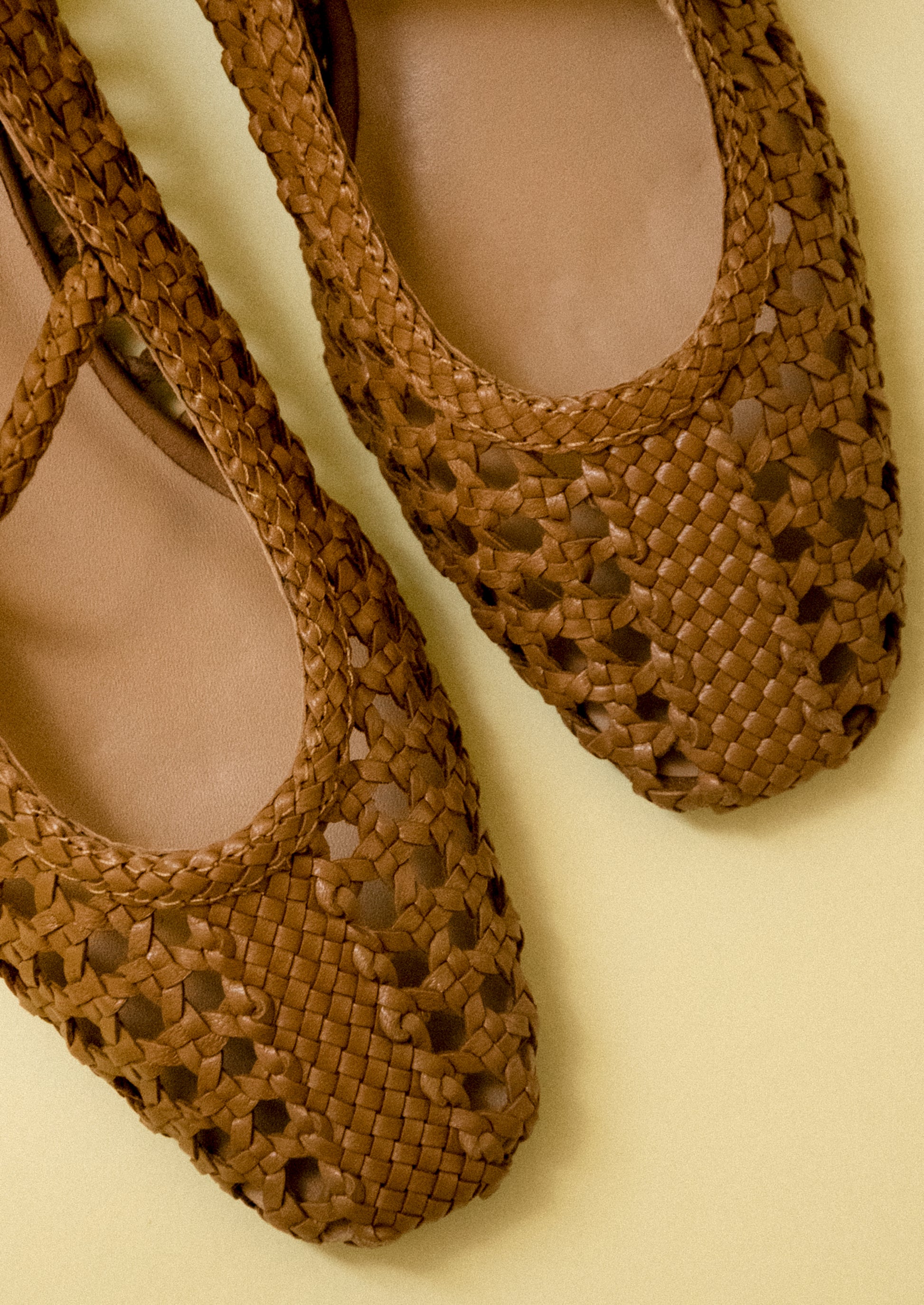A pair of brown open weave ballet flats.