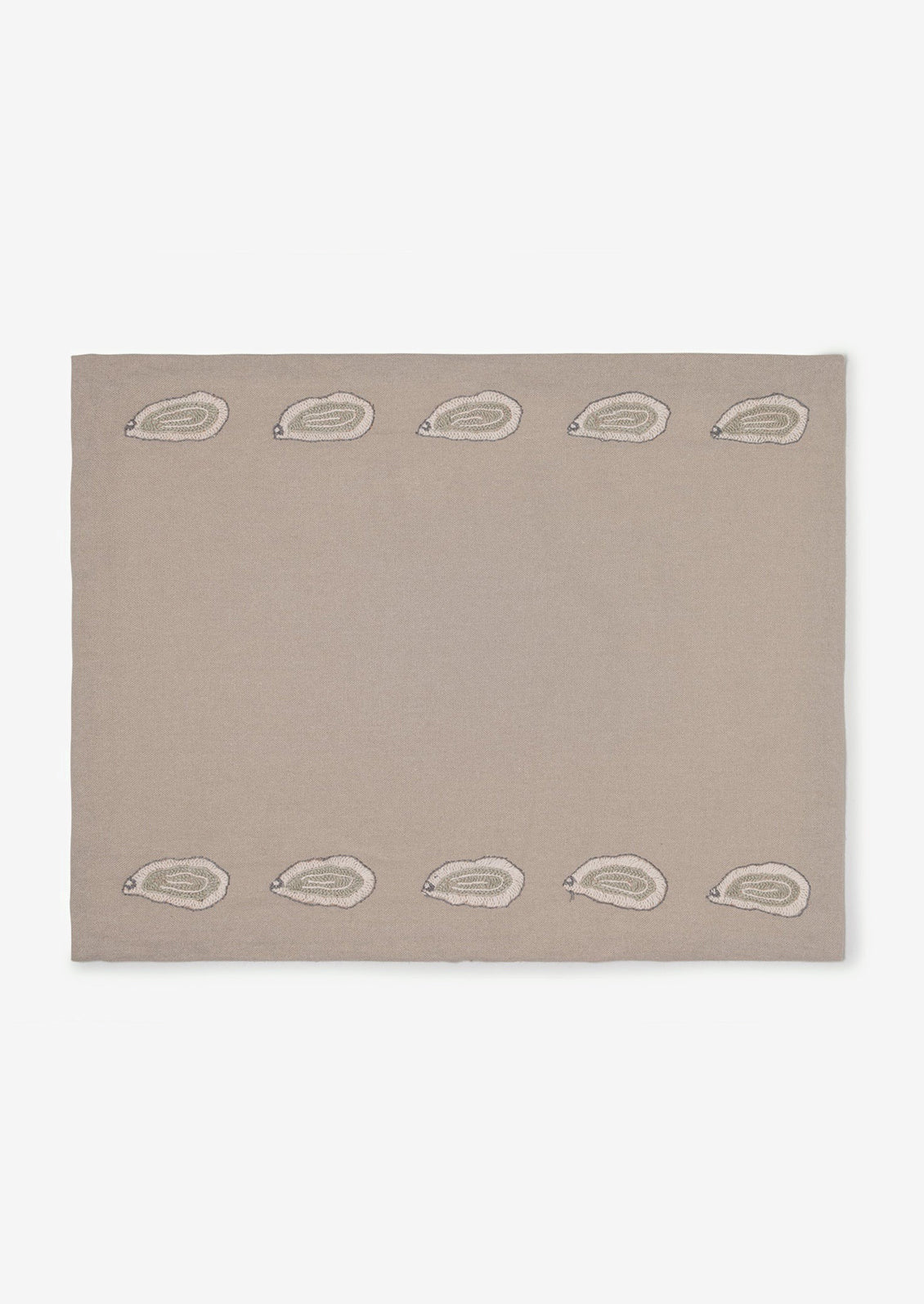 A grey cotton placemat with oyster embroidery on top and bottom.