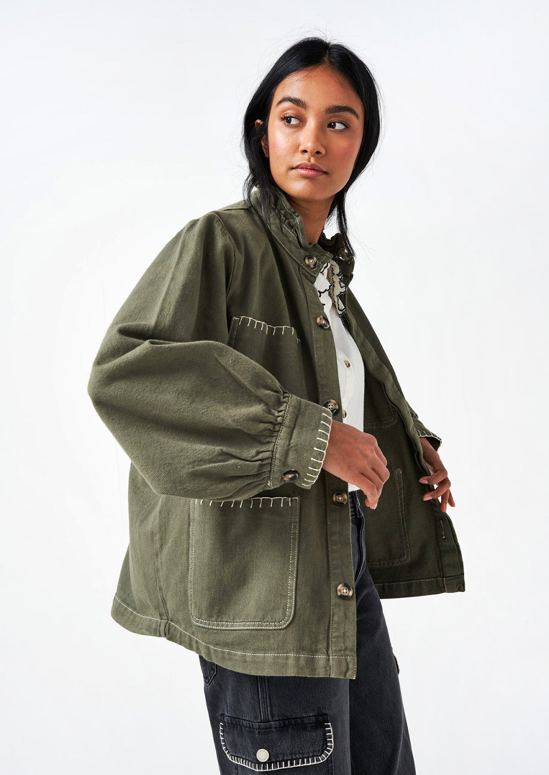 Woman wearing a khaki green cotton jacket. 