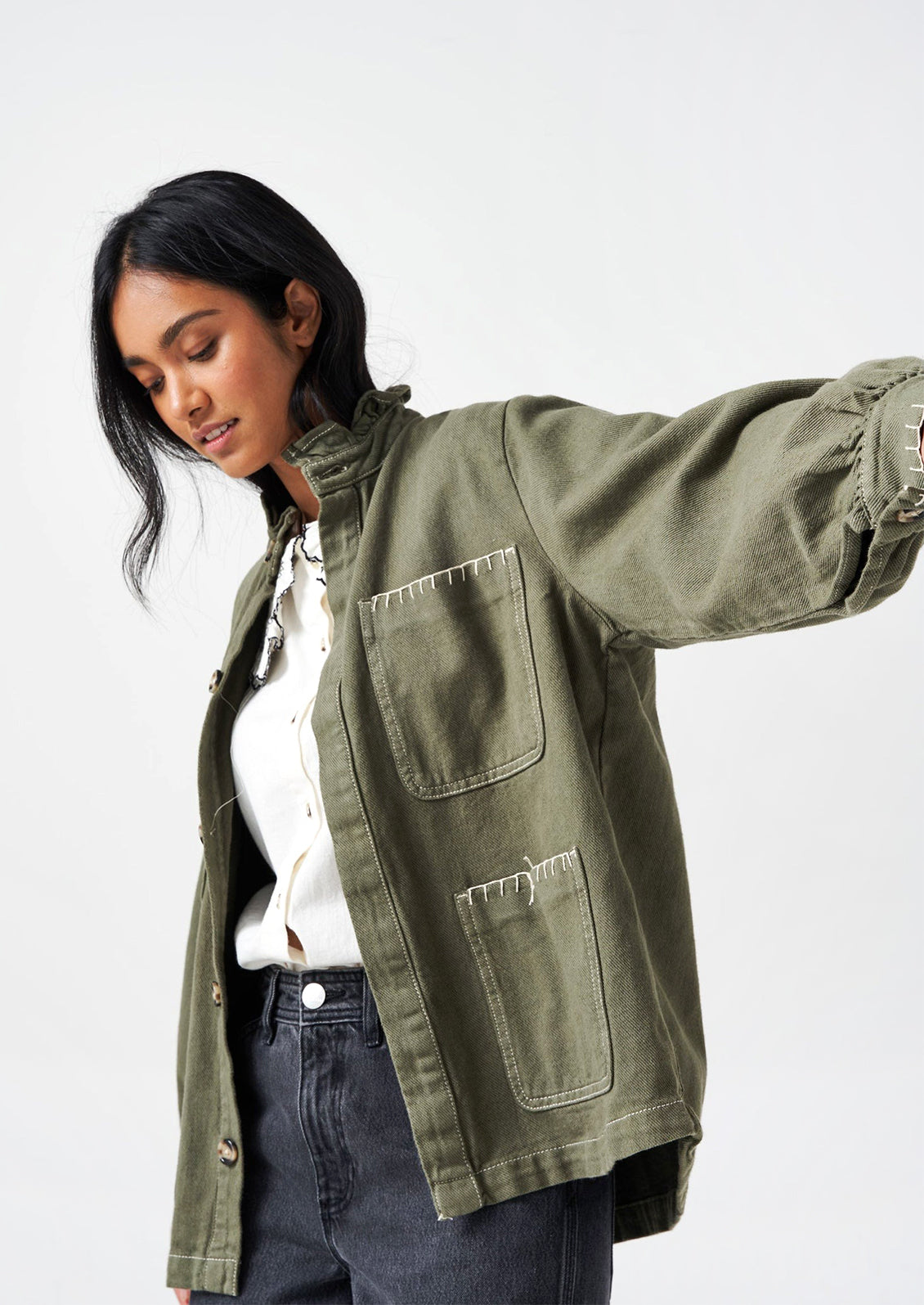 Woman wearing a khaki green army jacket. 