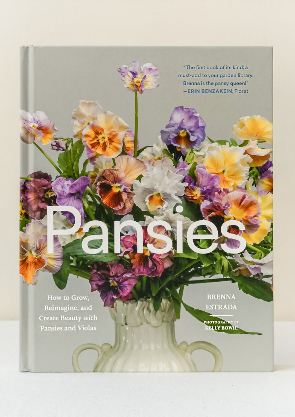 A book titled "Pansies" by Brenna Estrada standing upright on a table.