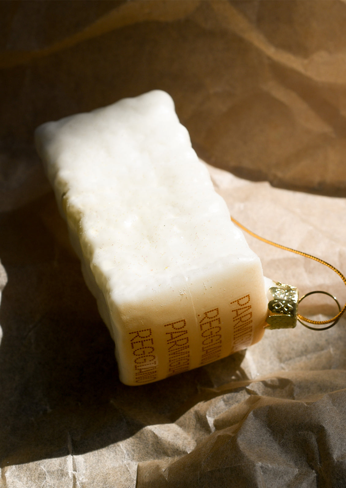 A glass ornament designed to look like a wedge of parmesan cheese.