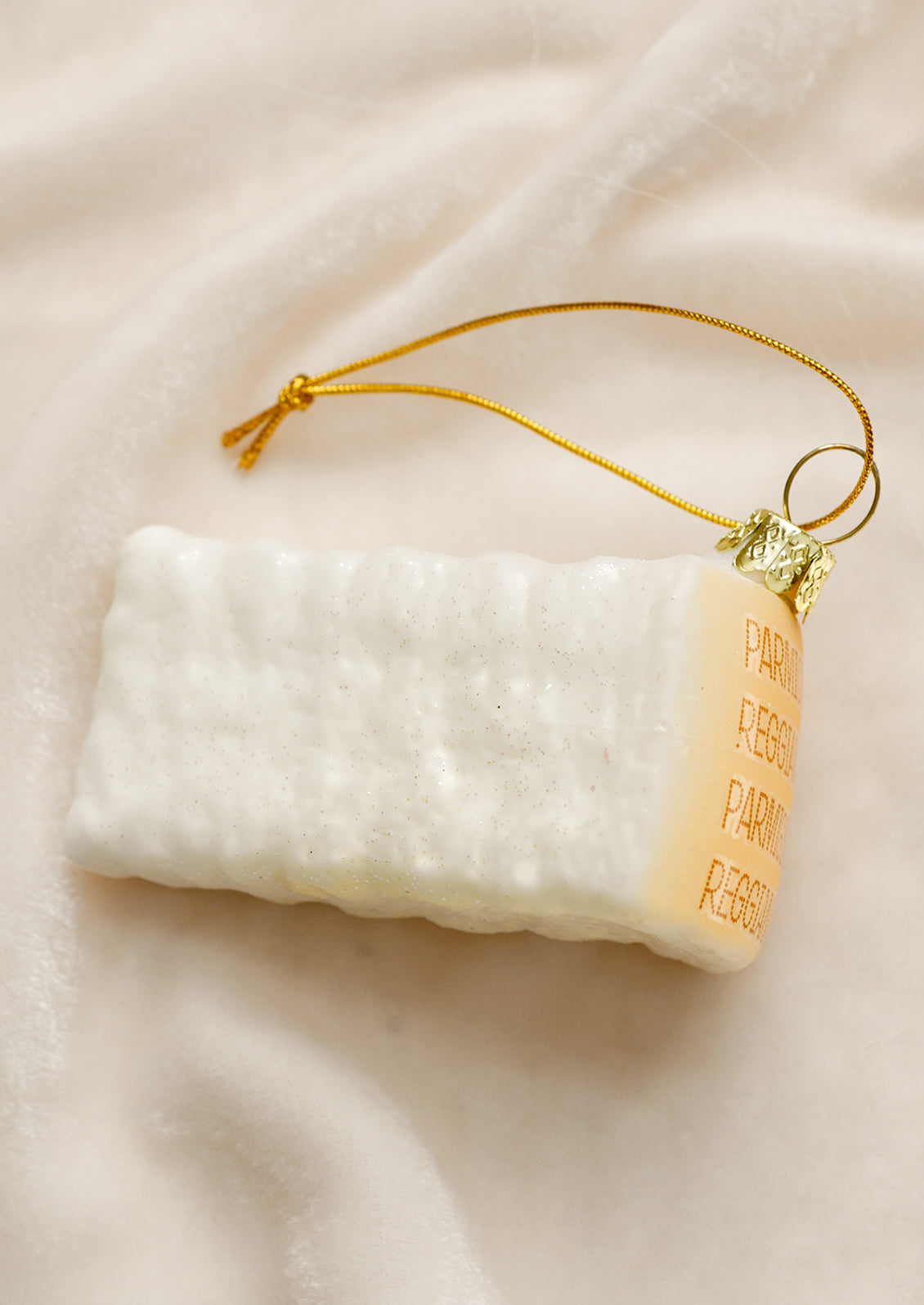 A glass ornament designed to look like a wedge of parmesan cheese.